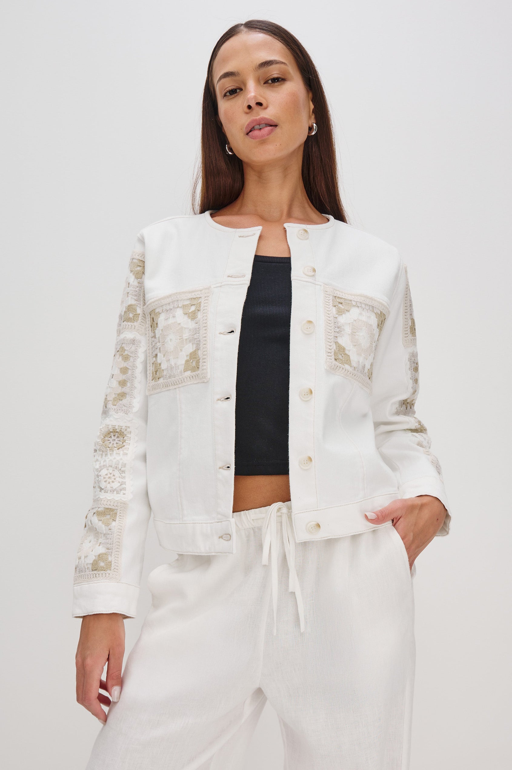 Lido collarless denim jacket with contrast embroidery details, chest pockets and embellishment buttons in vintage ecru crochet colorway. Front view on model.