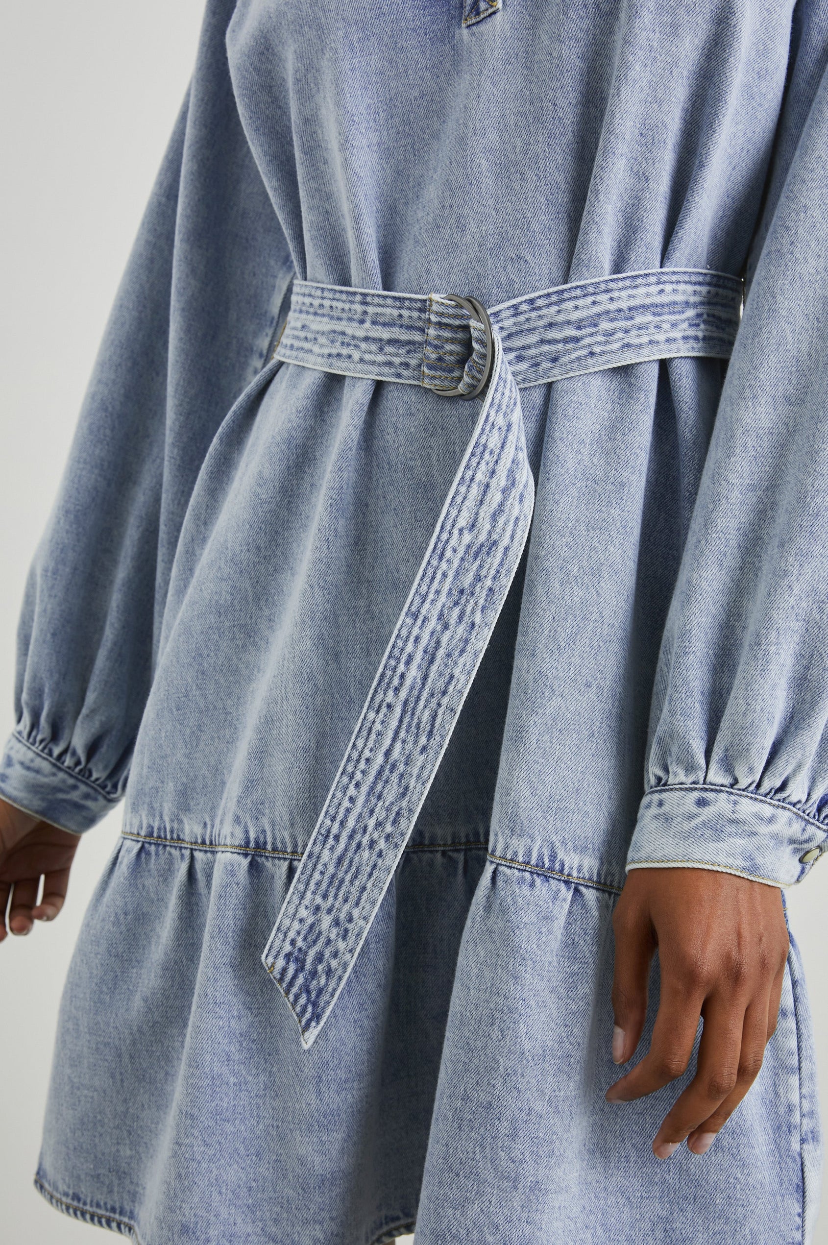 Lila Long-Sleeve Denim Mini Dress with a Fabric Double Ring Belt, a V Neck and Snap Cuffs in Faded Indigo Colorway - Front View Featured on Model 