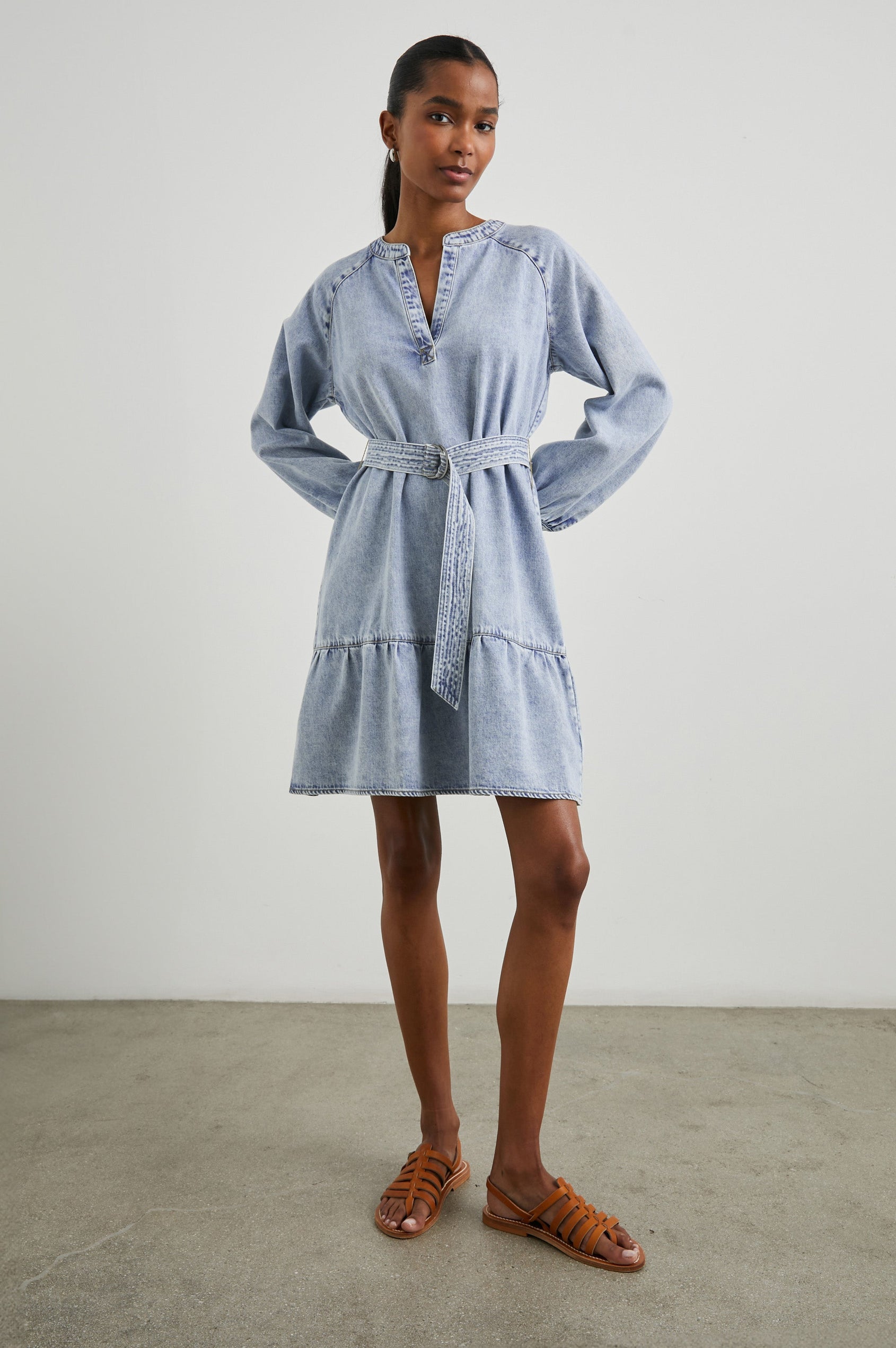 Lila Long-Sleeve Denim Mini Dress with a Fabric Double Ring Belt, a V Neck and Snap Cuffs in Faded Indigo Colorway - Front Full Body View Featured on Model 