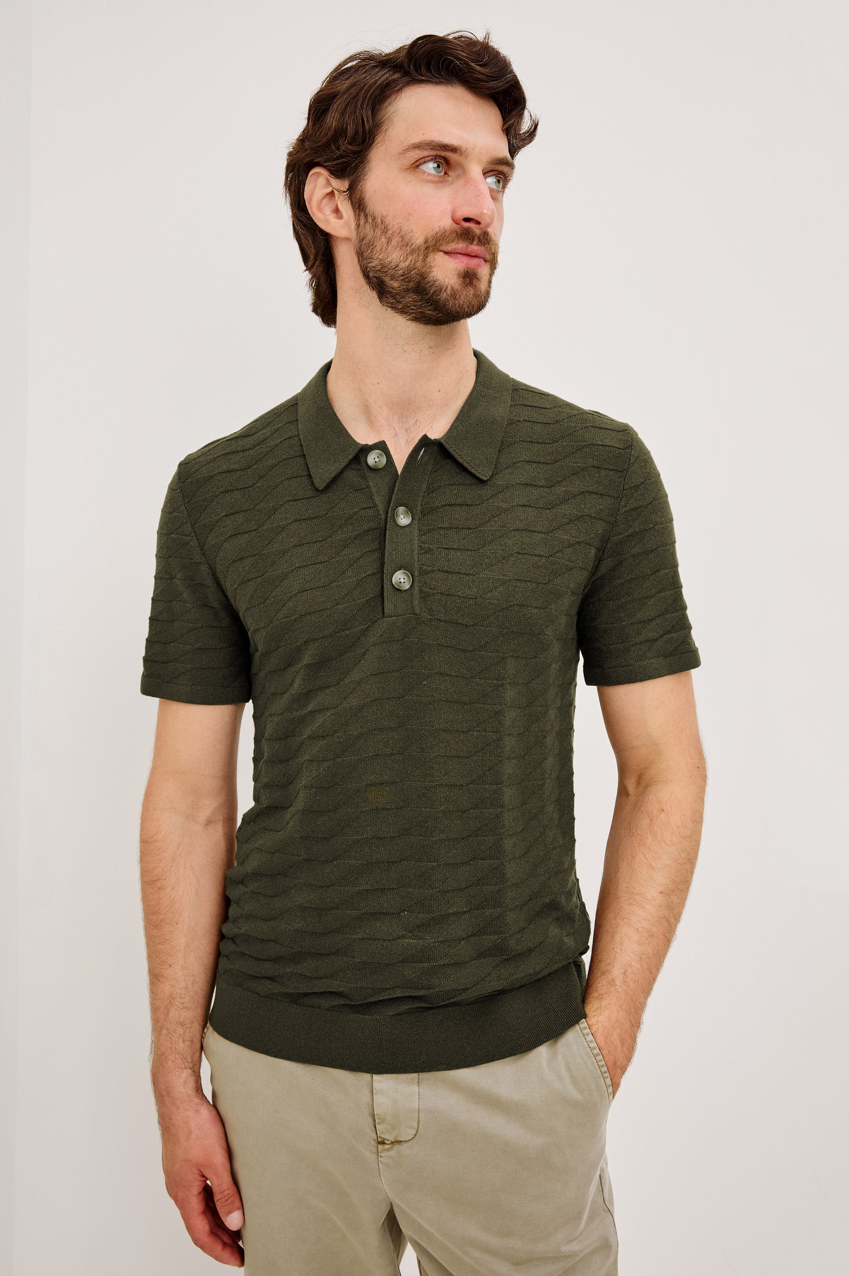 Linden Polo Shirt in Cotton Knit With Subtle Diamond Texture, Classic Fit, Quarter Button Placket, Short Sleeves, and Ribbed Trim in Ancient Olive Prism Colorway - Upper Body Front View Featured on Model