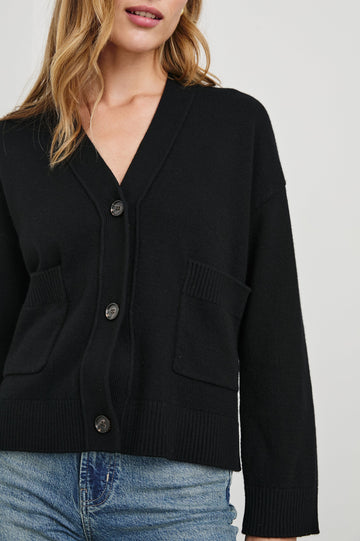 Lindi Long-Sleeve V Neck Cardigan with Three Button Closure, Two Front Patch Pockets and Ribbed Trim in Black Colorway - Front View Featured on Model