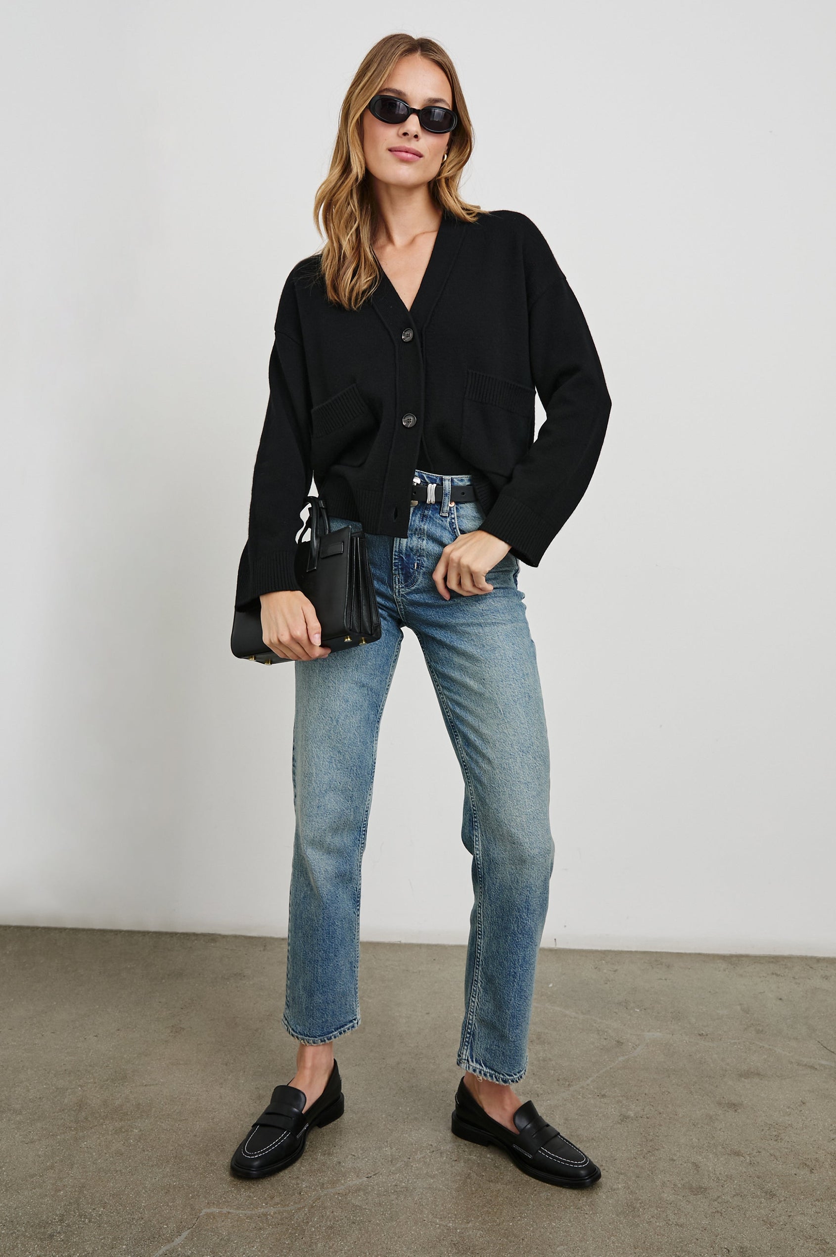 Lindi Long-Sleeve V Neck Cardigan with Three Button Closure, Two Front Patch Pockets and Ribbed Trim in Black Colorway - Front Full Body View Featured on Model