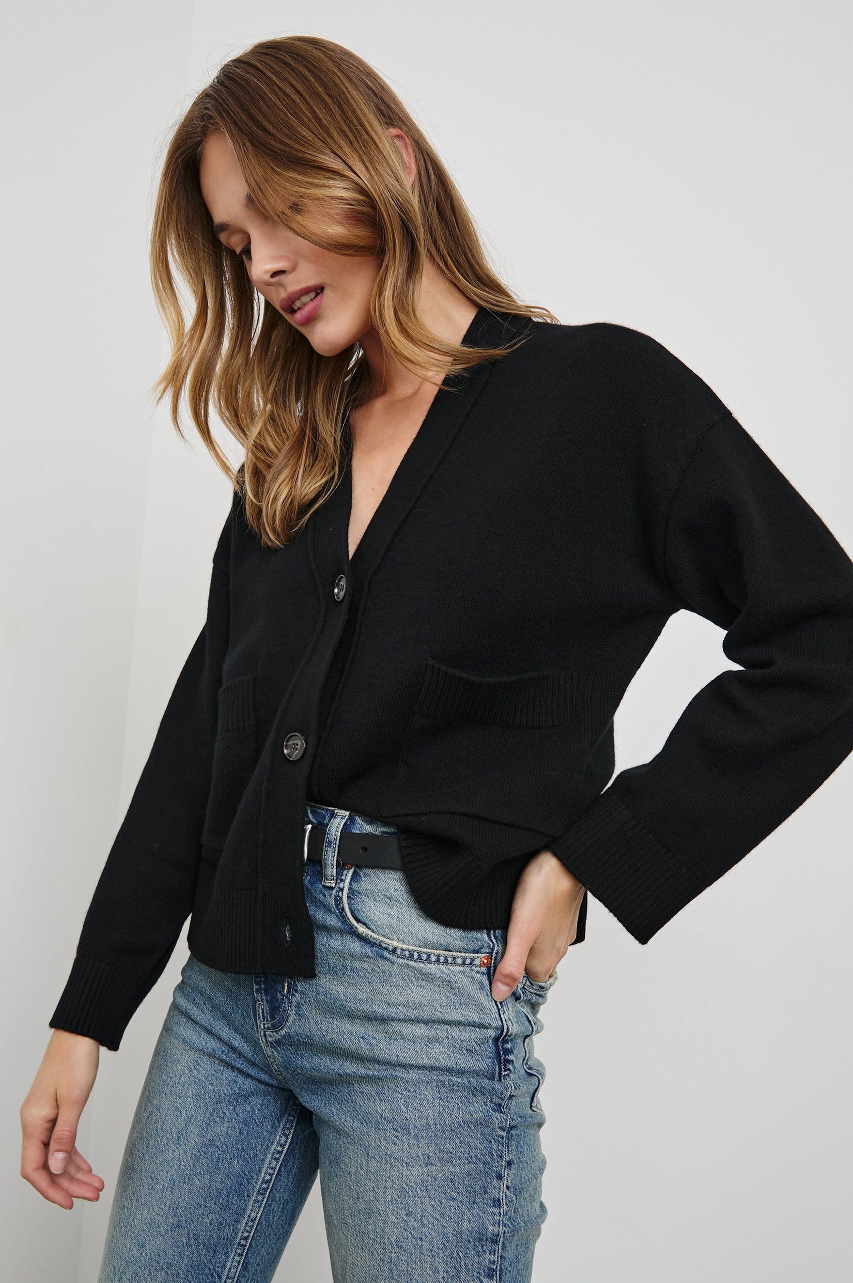 Lindi Long-Sleeve V Neck Cardigan with Three Button Closure, Two Front Patch Pockets and Ribbed Trim in Black Colorway - Front View Featured on Model