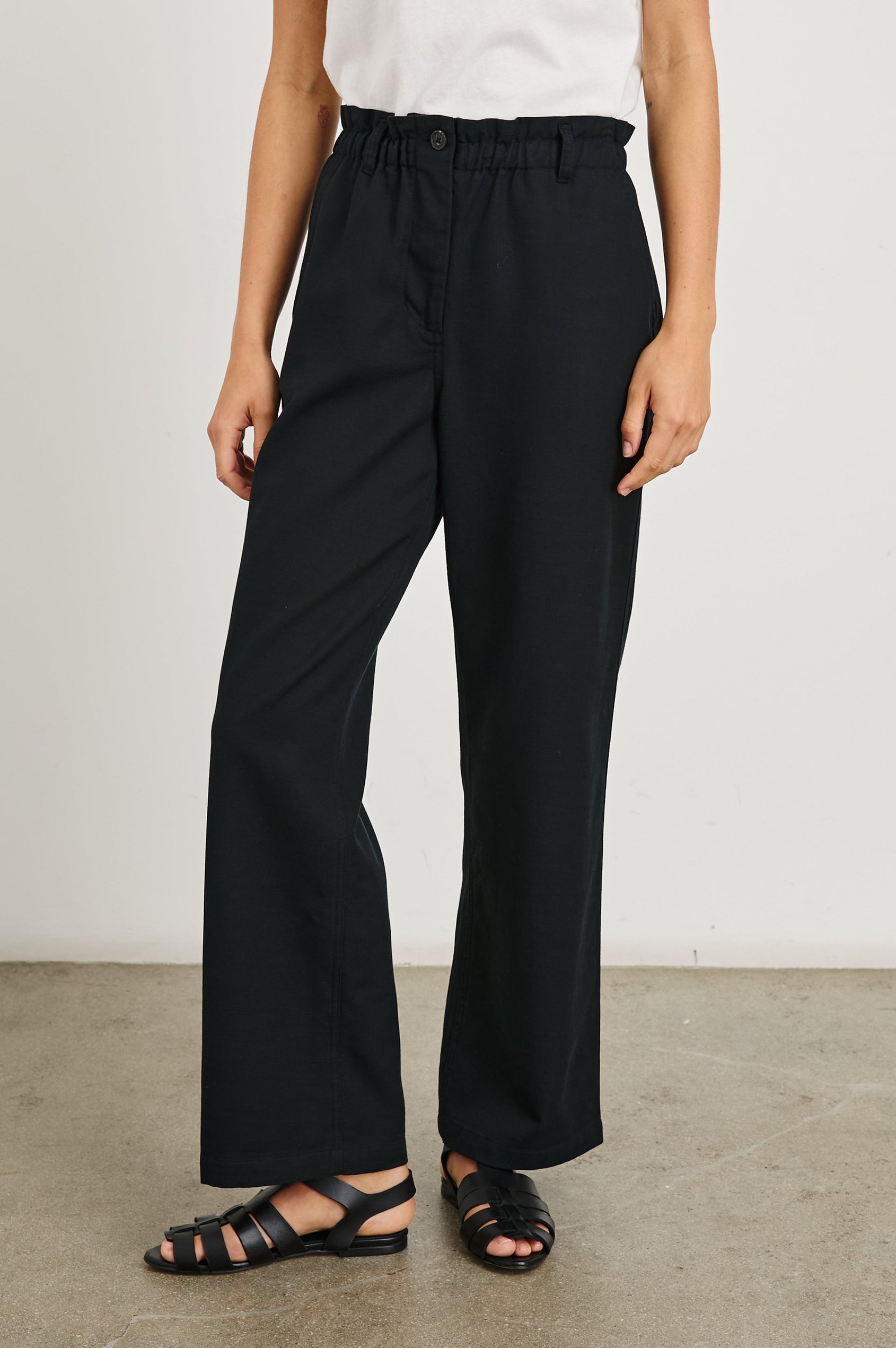 Lira Pants with a Paperbag Elastic Waist, Belt Loops, Two Front Pockets and Two Back Welt Pockets in Black Colorway - Front View Featured on Model 