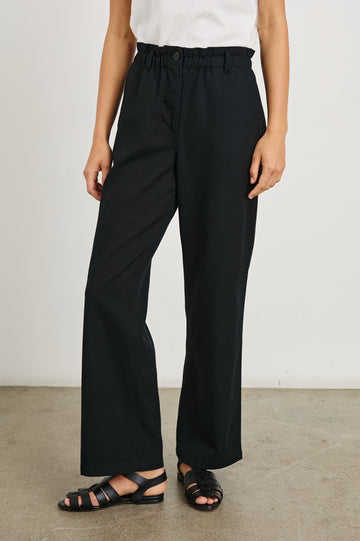 Lira Pants with a Paperbag Elastic Waist, Belt Loops, Two Front Pockets and Two Back Welt Pockets in Black Colorway - Front View Featured on Model 
