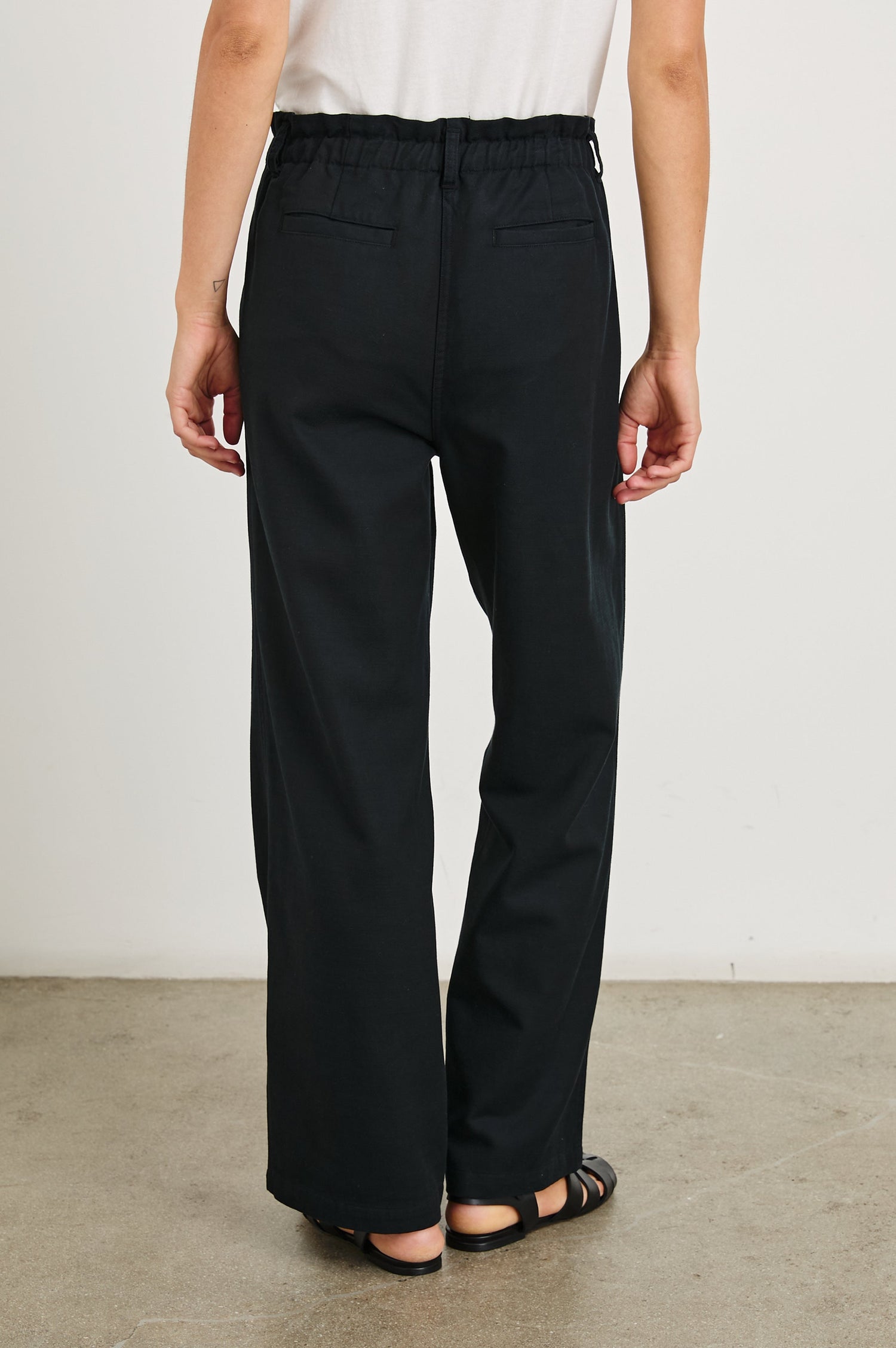Lira Pants with a Paperbag Elastic Waist, Belt Loops, Two Front Pockets and Two Back Welt Pockets in Black Colorway - Back View Featured on Model 