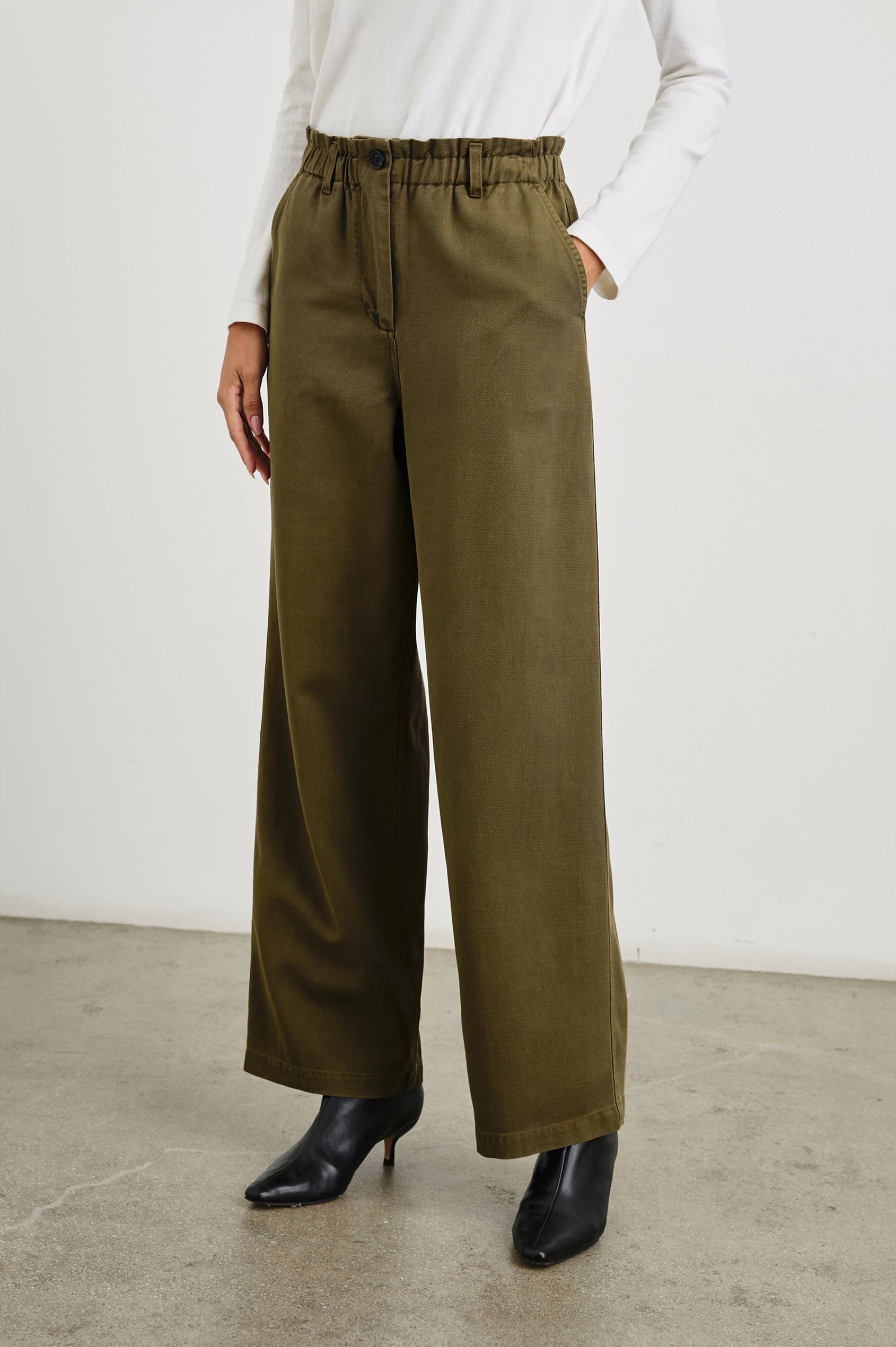 Lira Pants with a Paperbag Elastic Waist, Belt Loops, Two Front Pockets and Two Back Welt Pockets in Dark Olive Colorway - Front View Featured on Model 