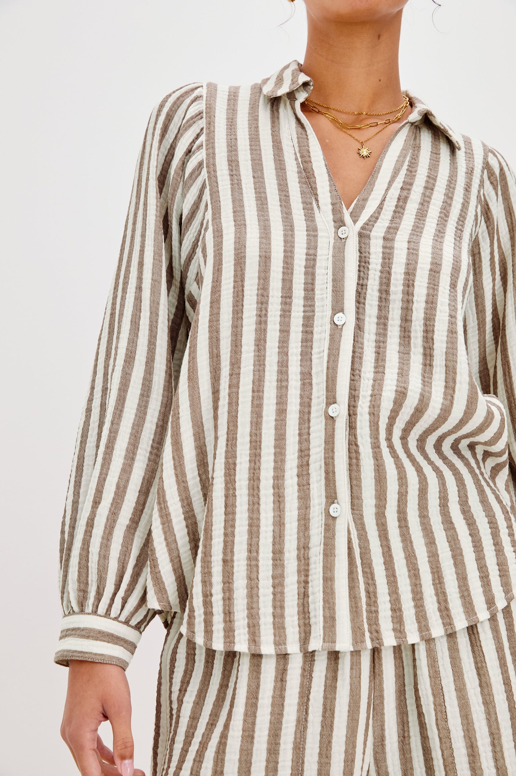 Lo V-Neck Collared Button Front Shirt with Long Sleeves and a Curved Hem in Brown and Cream Milos Stripe Colorway. Front View Shown on Model.
