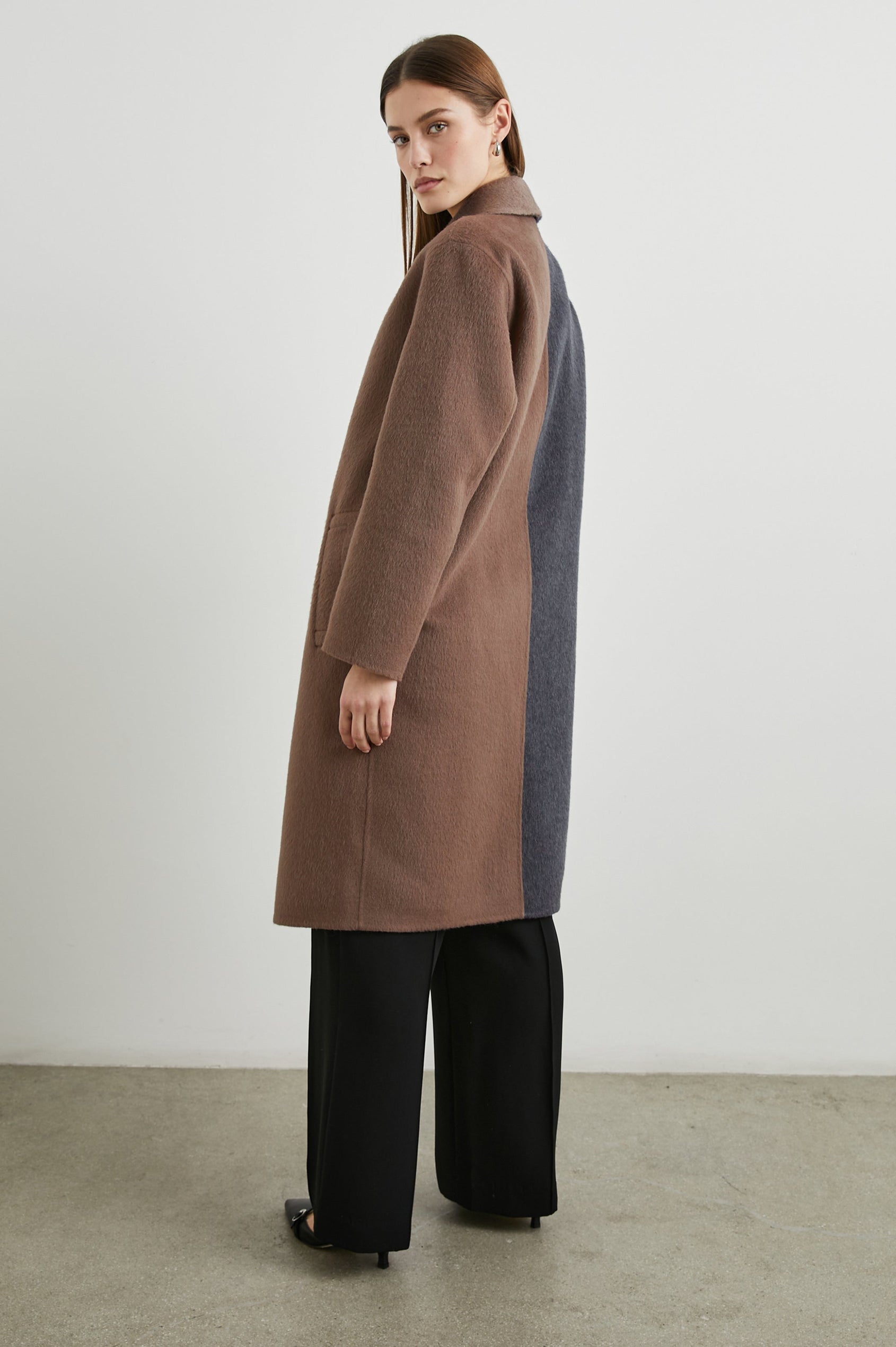 Lore Knee-Length Coat with Two Button Closure, Notched Lapels and Two Front Pockets in Charcoal Mink Mix Colorway, Left Half of Jacket is Mink and the Right Half is Charcoal  - Side Full Body View Featured on Model