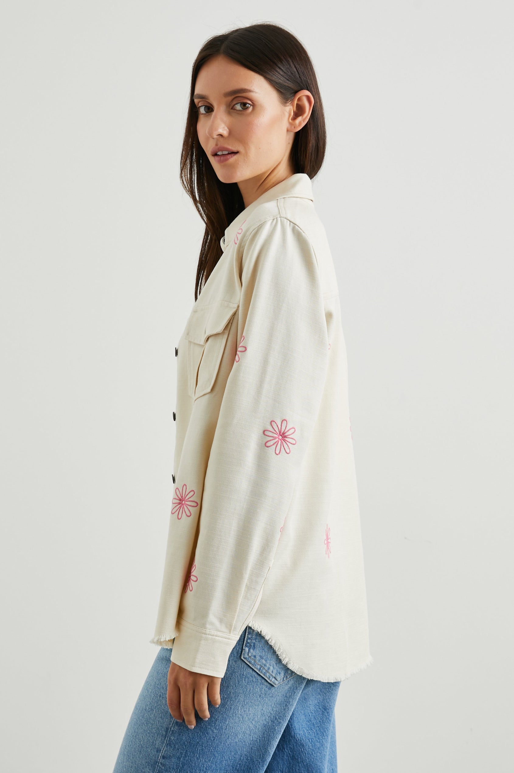 Loren Long-Sleeve Shirt Jacket with Button Closure, Two Chest Button Flap Pockets and a Raw Hem in Ecru Colorway, with Pink Flowers - Side View Featured on Model