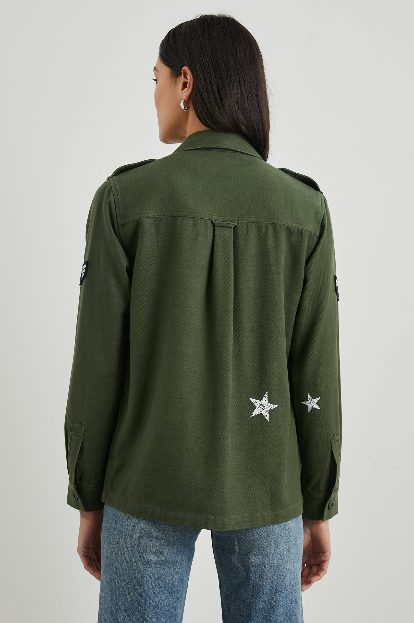 Loren Long-Sleeve Shirt Jacket with Button Closure, Two Chest Button Flap Pockets, a Military Patch on Each Arm, a Military Number above One Chest Pocket, and Button Shoulder Tabs in Military Olive Colorway, with White Stars - Back View Featured on Model