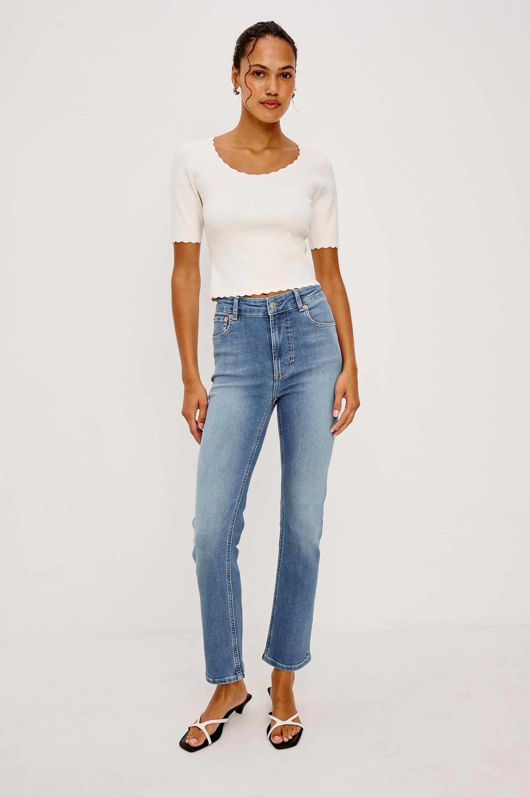 Louanna Fitted Cropped Top in Compact Knit With Scallop-Trimmed Scoop Neckline Short Sleeves and Hem in Ivory Colorway - Full Body Front View Featured on Model