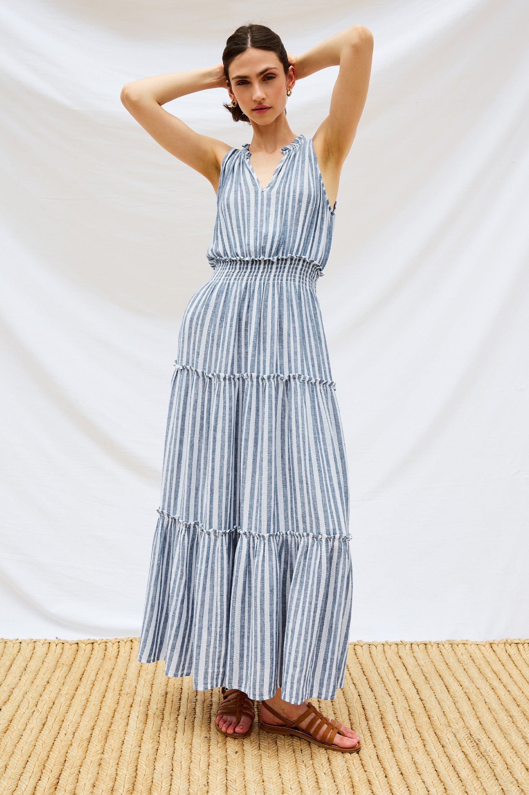 Loulou V-Neck Midi Dress with Smocked Elastic Waistband and a Multi Tiered Skirt in Blue/White Jalisco Stripe Colorway. Stylized Full Body Front View Shown on Model.
