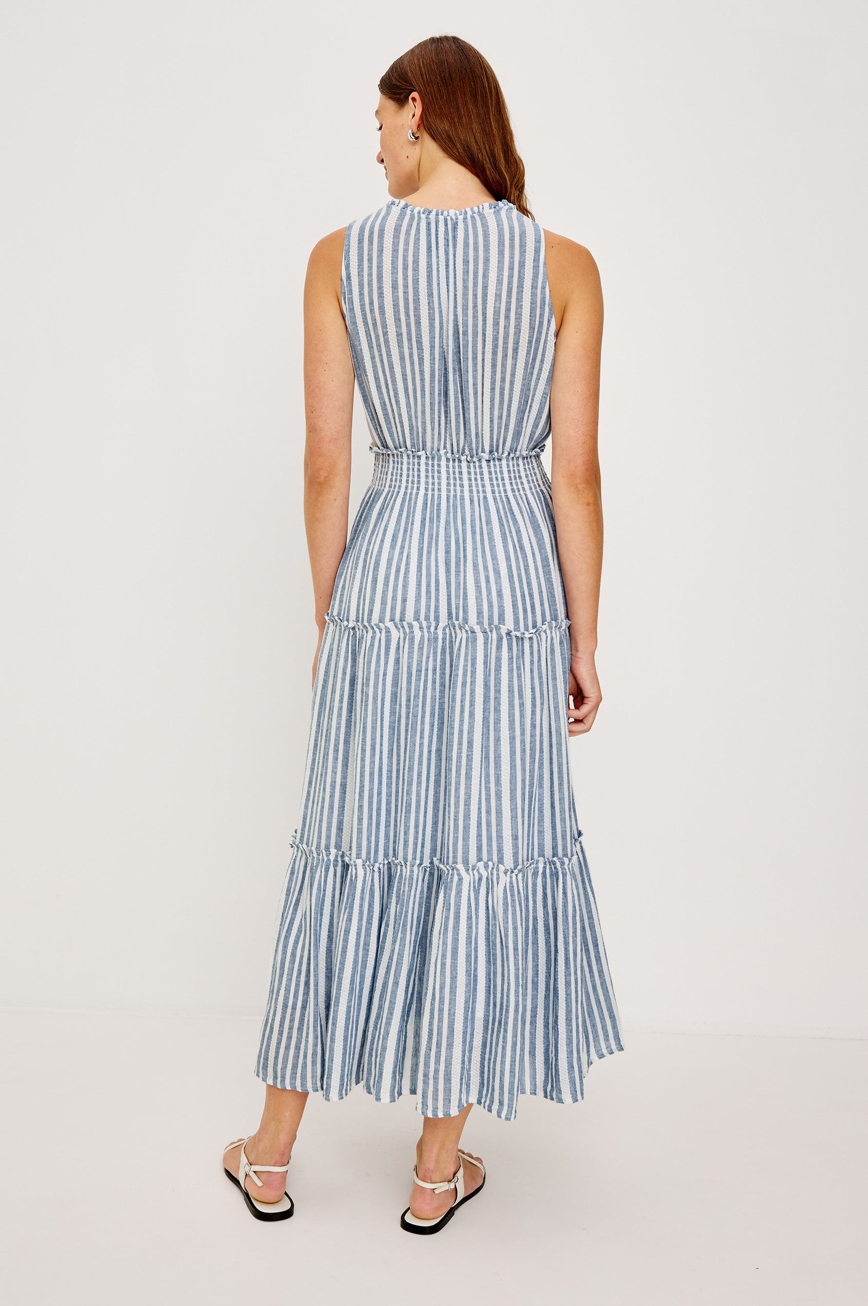 Loulou V-Neck Midi Dress with Smocked Elastic Waistband and a Multi Tiered Skirt in Blue/White Jalisco Stripe Colorway. Full Body Back View Shown on Model.