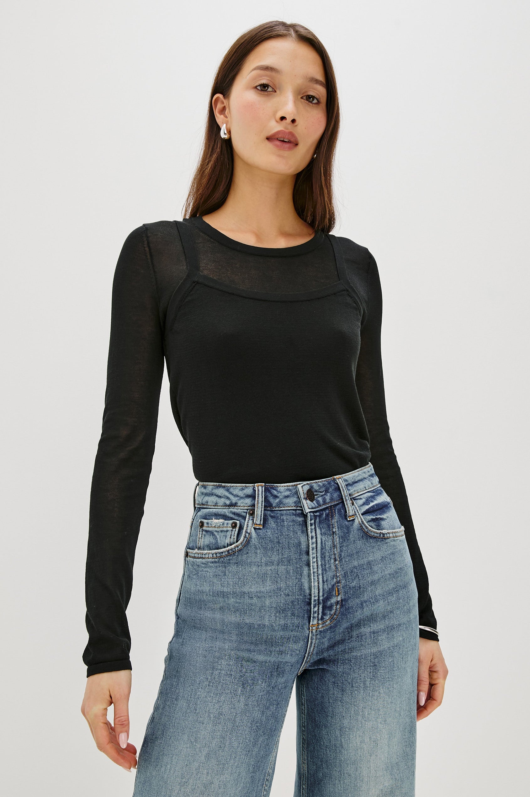 Lovisa is a cotton top designed with a layered look, featuring a lightweight tank underneath a long-sleeve crewneck in Black Colorway. The tonal pairing creates built-in dimension with a casual, modern feel. Front View featured on model, shirt tucked in.