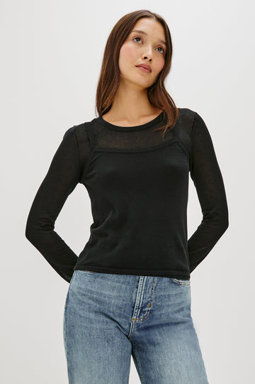 Lovisa is a cotton top designed with a layered look, featuring a lightweight tank underneath a long-sleeve crewneck in Black Colorway. The tonal pairing creates built-in dimension with a casual, modern feel. Front View featured on model.