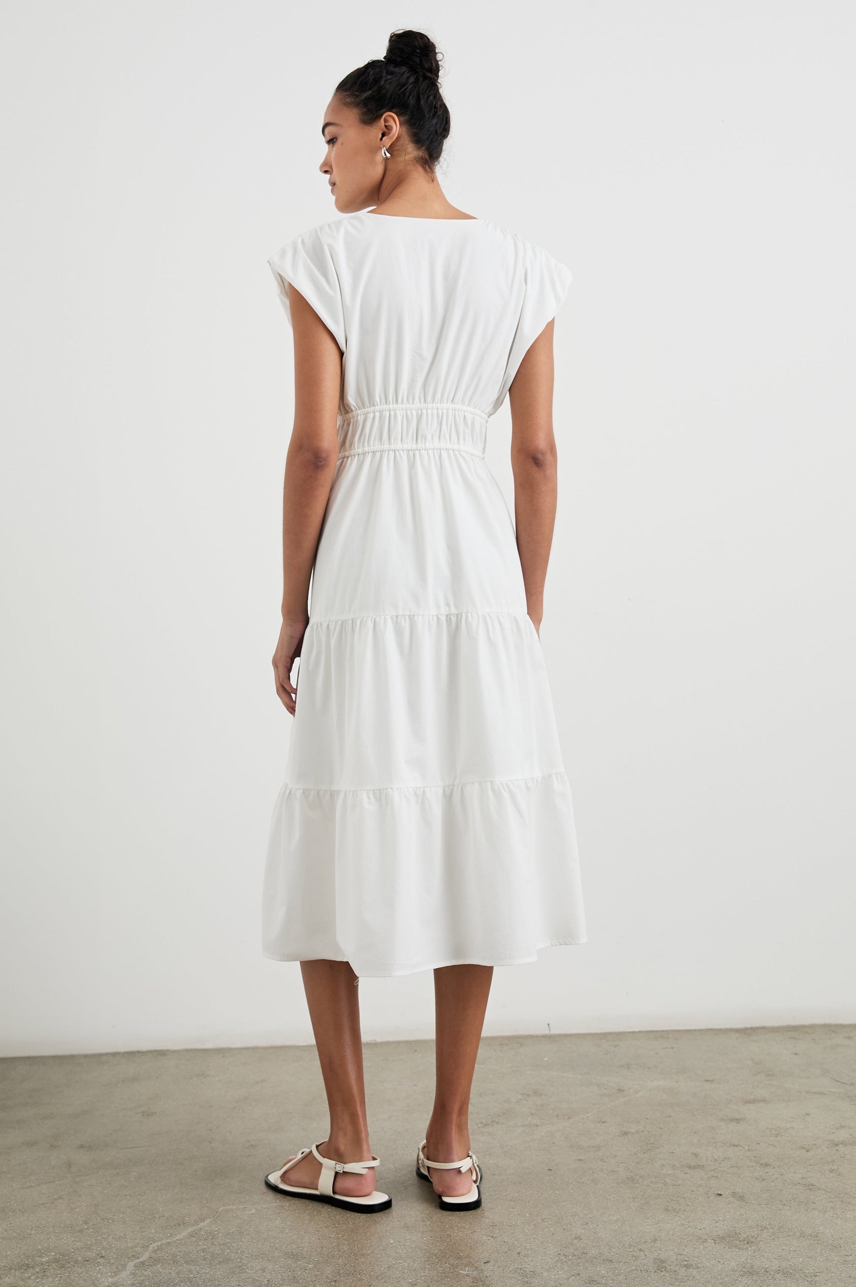 Lucia Midi Dress with Cap Sleeves, a Crossover V neckline, an Elastic Waist with Ties, and a Tiered Skirt in White Colorway - Back Full Body View Featured on Model
