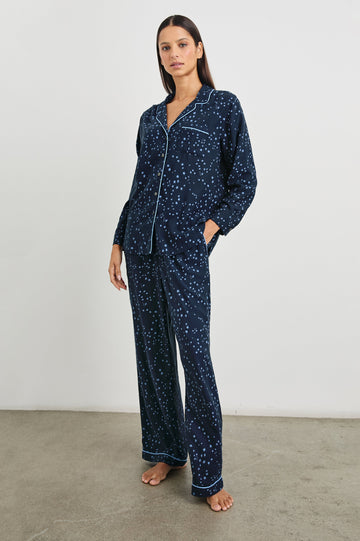 Luna Pajama Set with a Long Sleeve, Button Up, V Neck Top with a Chest Patch Pocket and Pants with Two Front Pockets in Stellar Colorway, blue starts on Dark Blue - Front Full Body View Featured on Model  