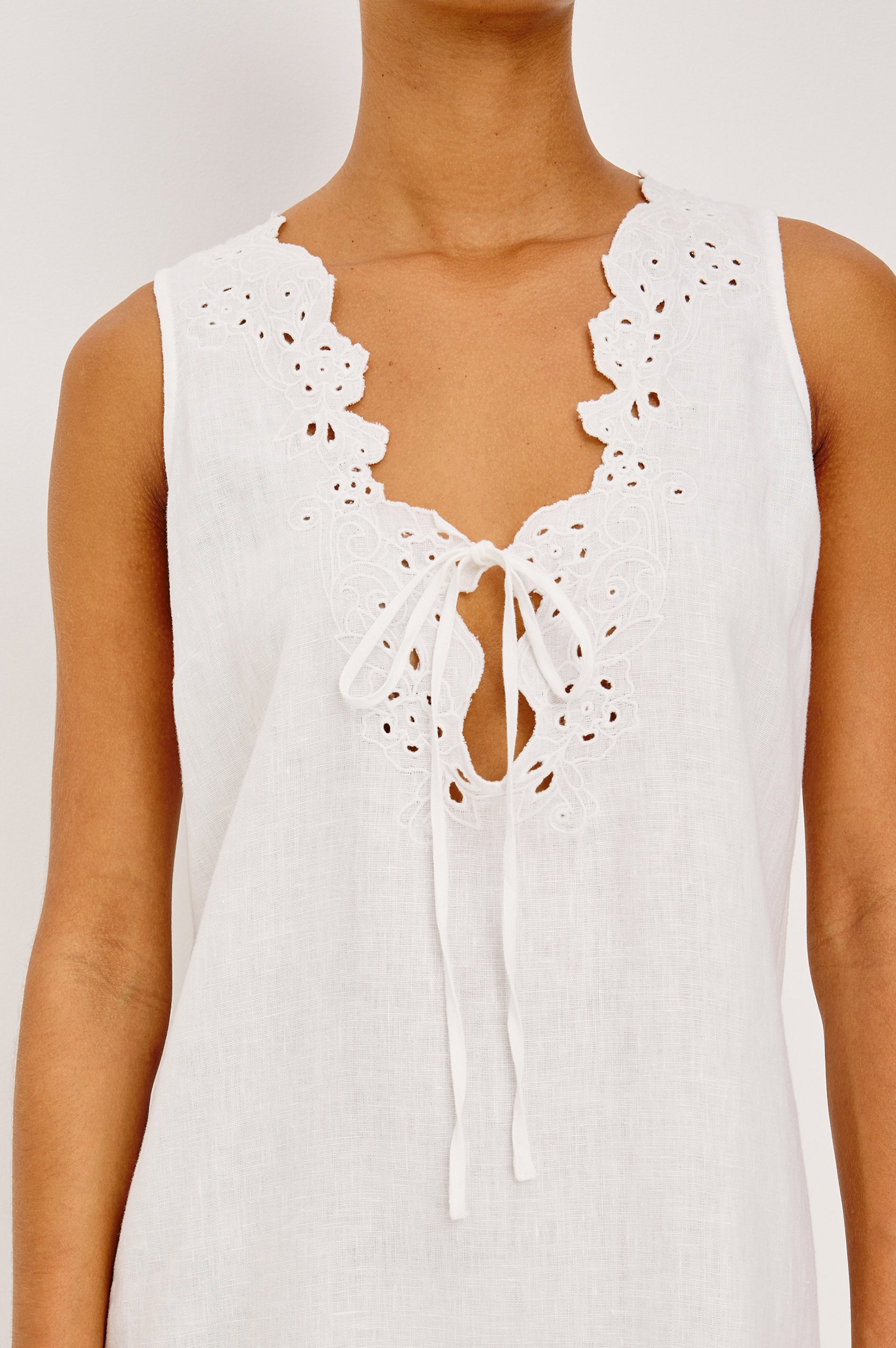 Lunetta Mini Shift Dress in Heavy Linen With V-Neckline, Embroidered Cutwork Detailing, and Loose Fit in White Colorway - Upper Body Front View Featured on Model