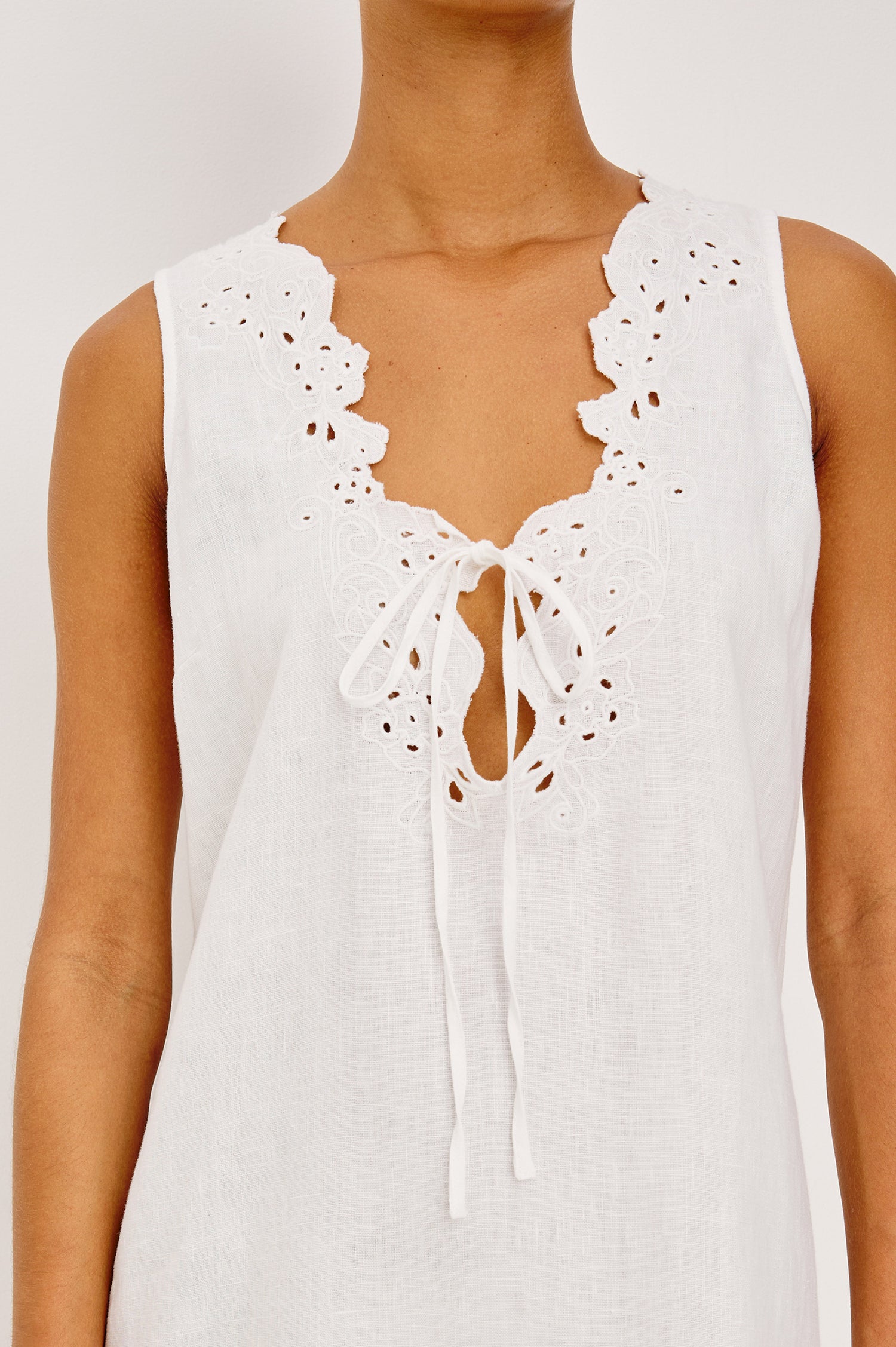 Lunetta Mini Shift Dress in Heavy Linen With V-Neckline, Embroidered Cutwork Detailing, and Loose Fit in White Colorway - Upper Body Front View Featured on Model