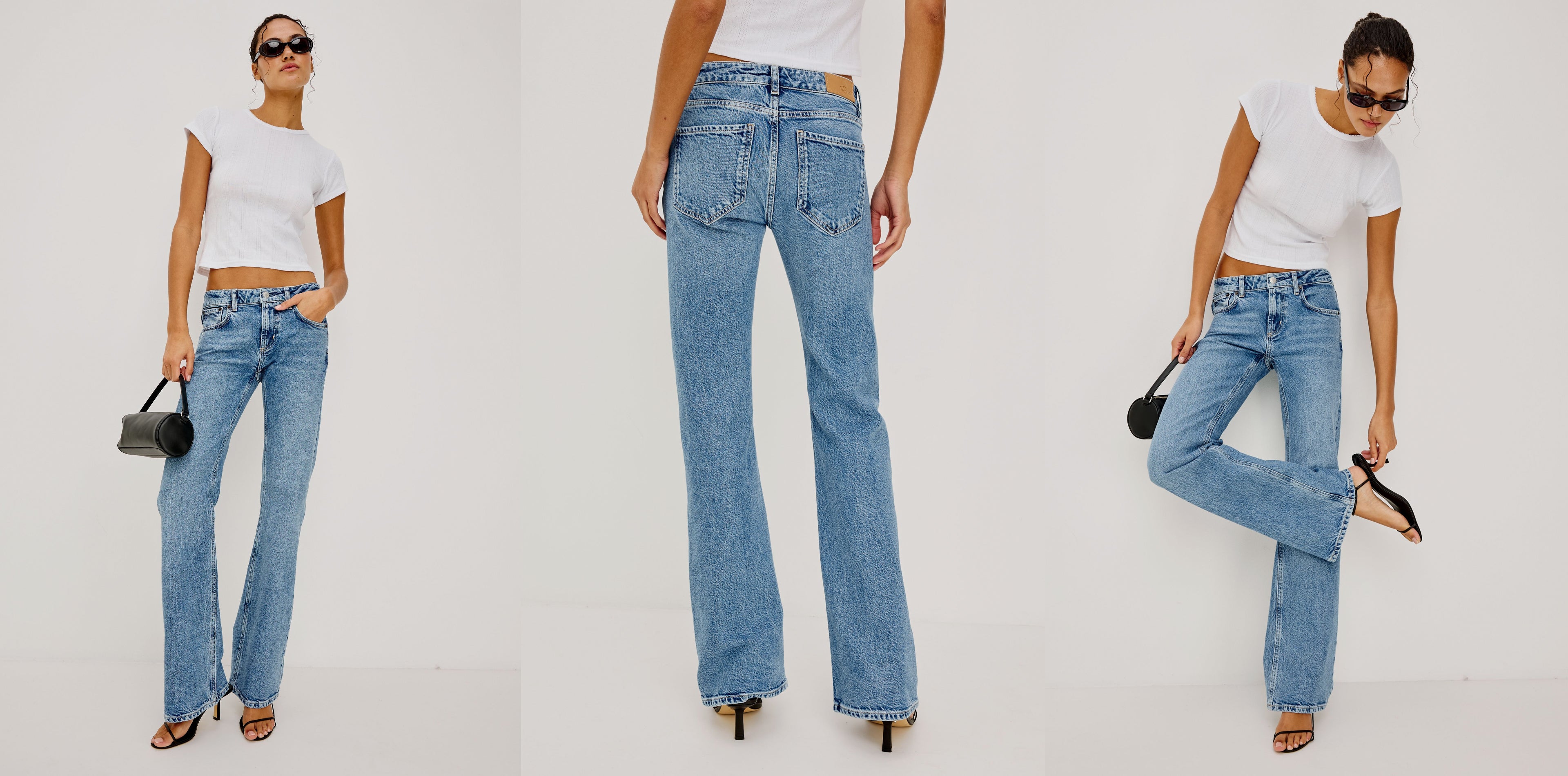 Woman wearing light blue jeans and a white top, posing against a plain background.