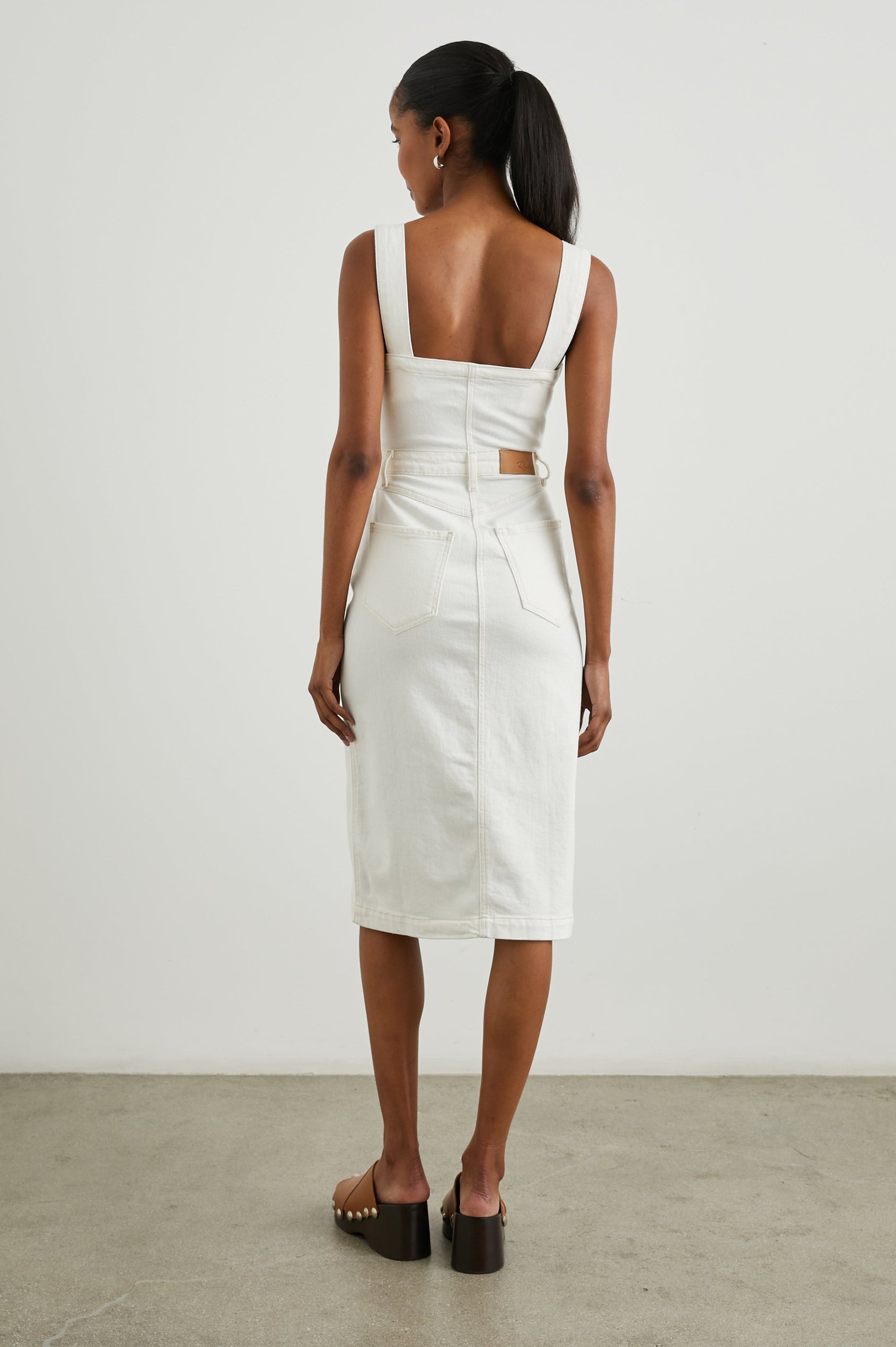 Malibu Sleeveless Denim Midi Dress with Shoulder Straps, Buttons Down the Front, a Square Neckline in the Front and Back, Two Front Pockets and Two Back Patch Pockets in Vintage Ecru Colorway - Back Full Body View Featured on Model