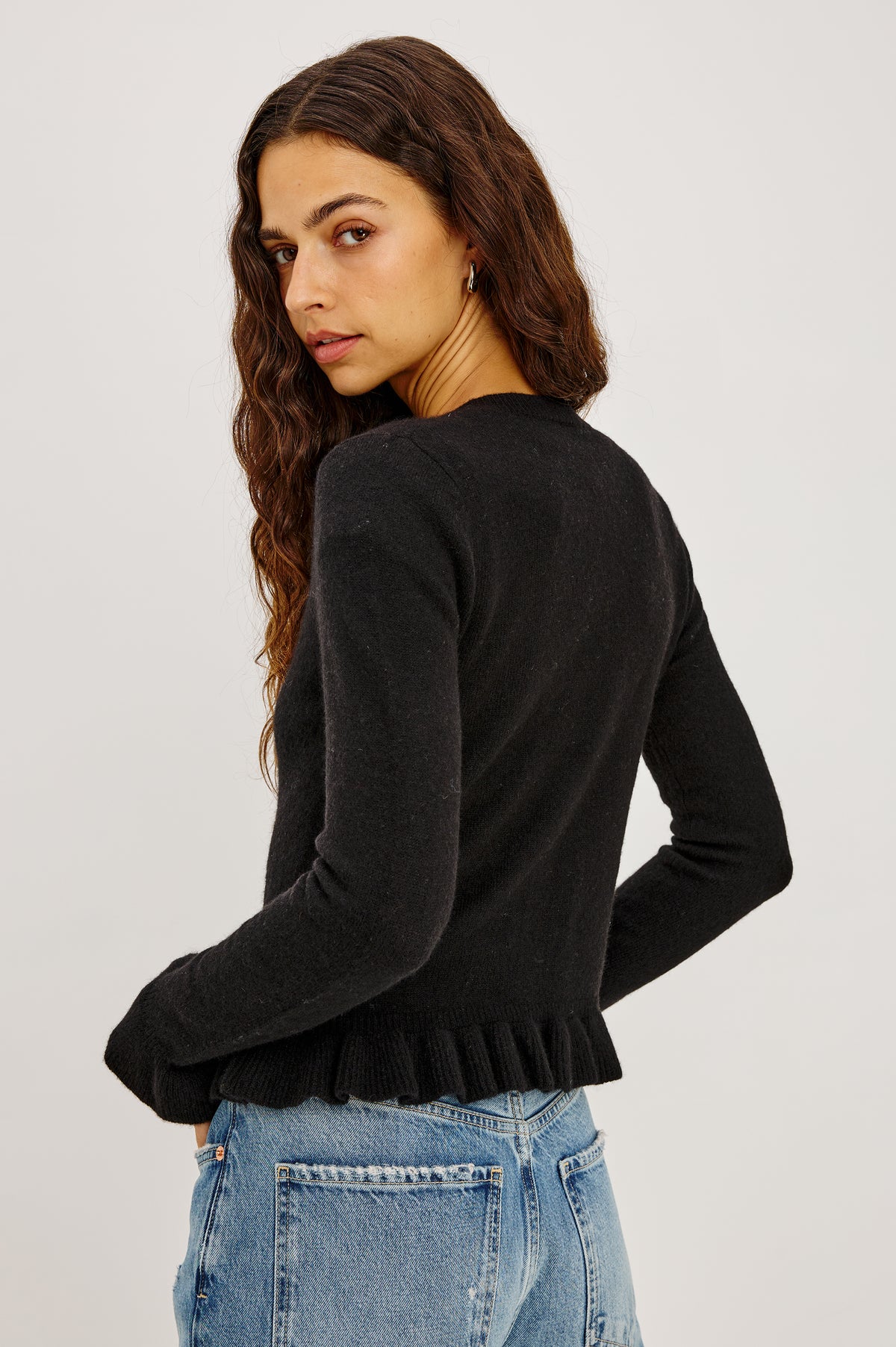 Mandy Sweater in Cashmere-Cotton-Wool Blend Knit Front Buttons, Long Sleeves, Classic Slightly Cropped Fit, and Ribbed Ruffle Trim in Black Colorway - Back Crop View Featured on Model.
