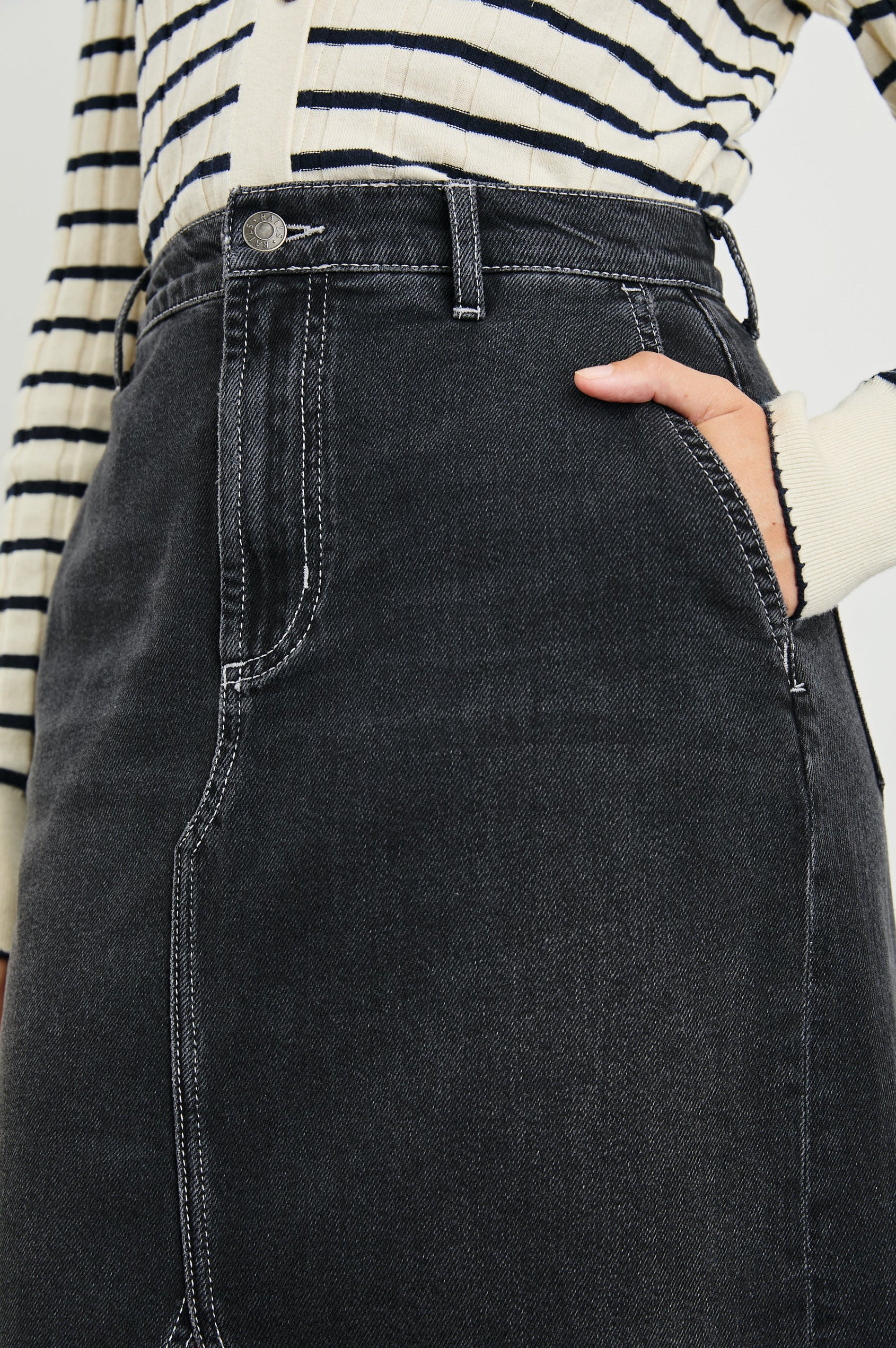 Manhattan Midi Denim Skirt with a Raw Hem, a Front Center Thigh Slit, Belt Loops, Two Front Pockets and Two Back Patch Pockets in Eclipse Colorway, a Black - Front View Featured on Model