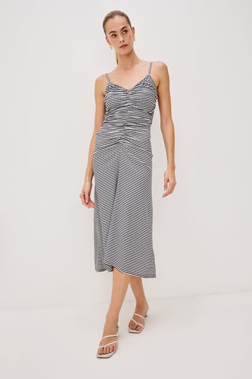 Mari Midi Dress with Spaghetti Straps, V-Front, A-Line Silhouette and Gathering Down Center Front in Navy Gingham Colorway. Full Body Front View Shown on Model.