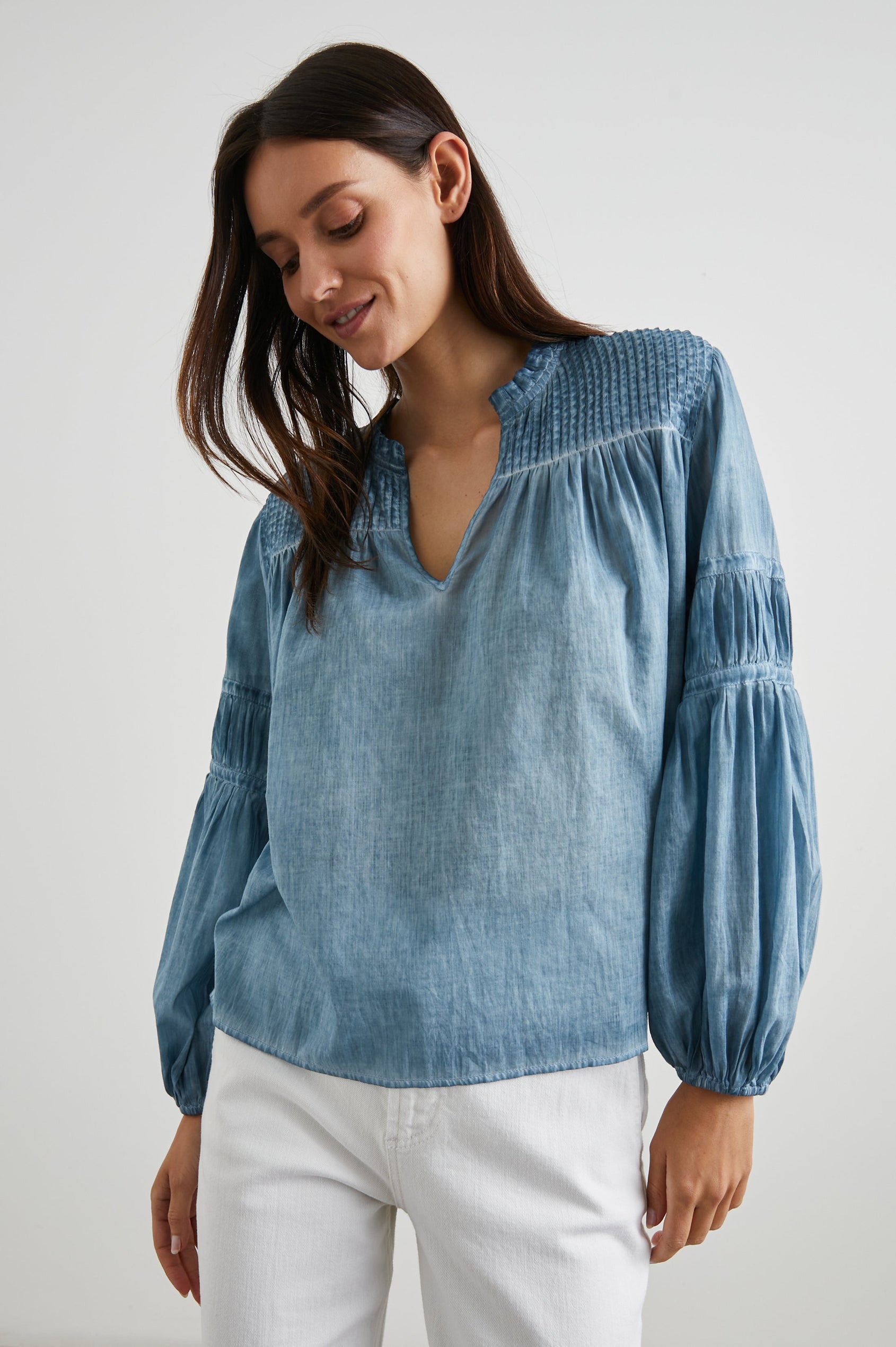 Marli Long-Sleeve Top with a V Neck, Ruffle Collar, Ruching on the Sleeves and Yoke Seam, Tiered Sleeves, and Pleats on the Yoke in Faded Blue Colorway - Front View Featured on Model 
