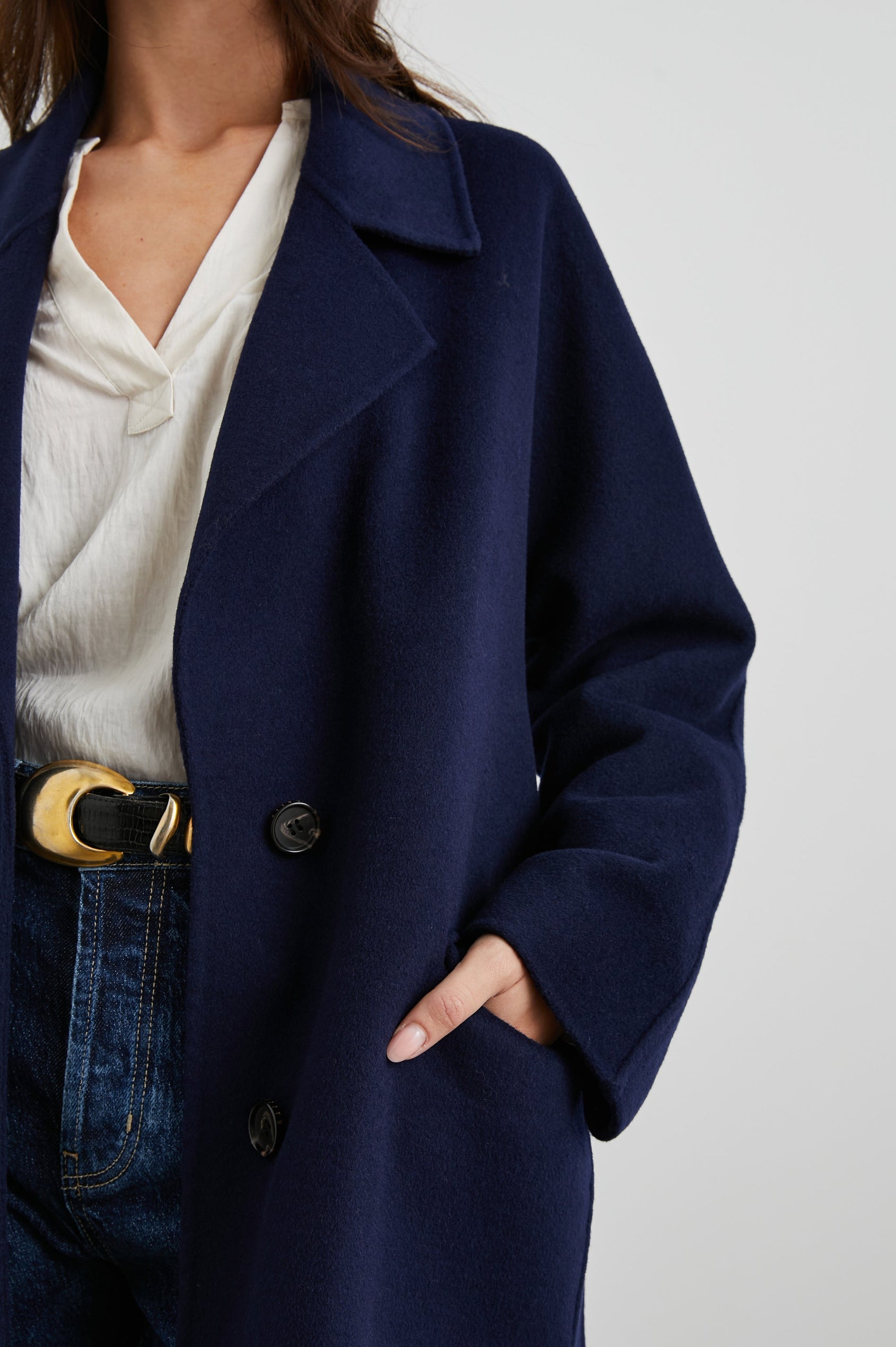 Marta Knee-Length Coat with Two Button Closure, Notched Lapels, Two Front Flap Pockets, and a Tie Belt in Navy Colorway - Front View Featured on Model 