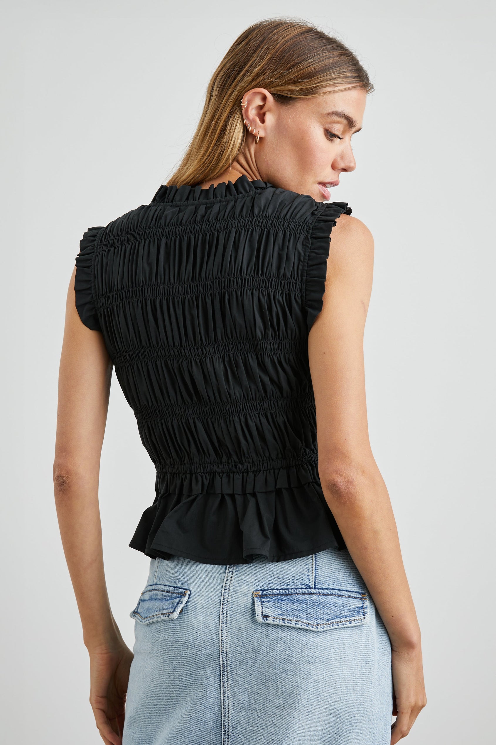 Martine Sleeveless Top with Ruffled Trim, a Deep V-Neck with Ties and Smocking in Black Colorway - Back View Featured on Model 