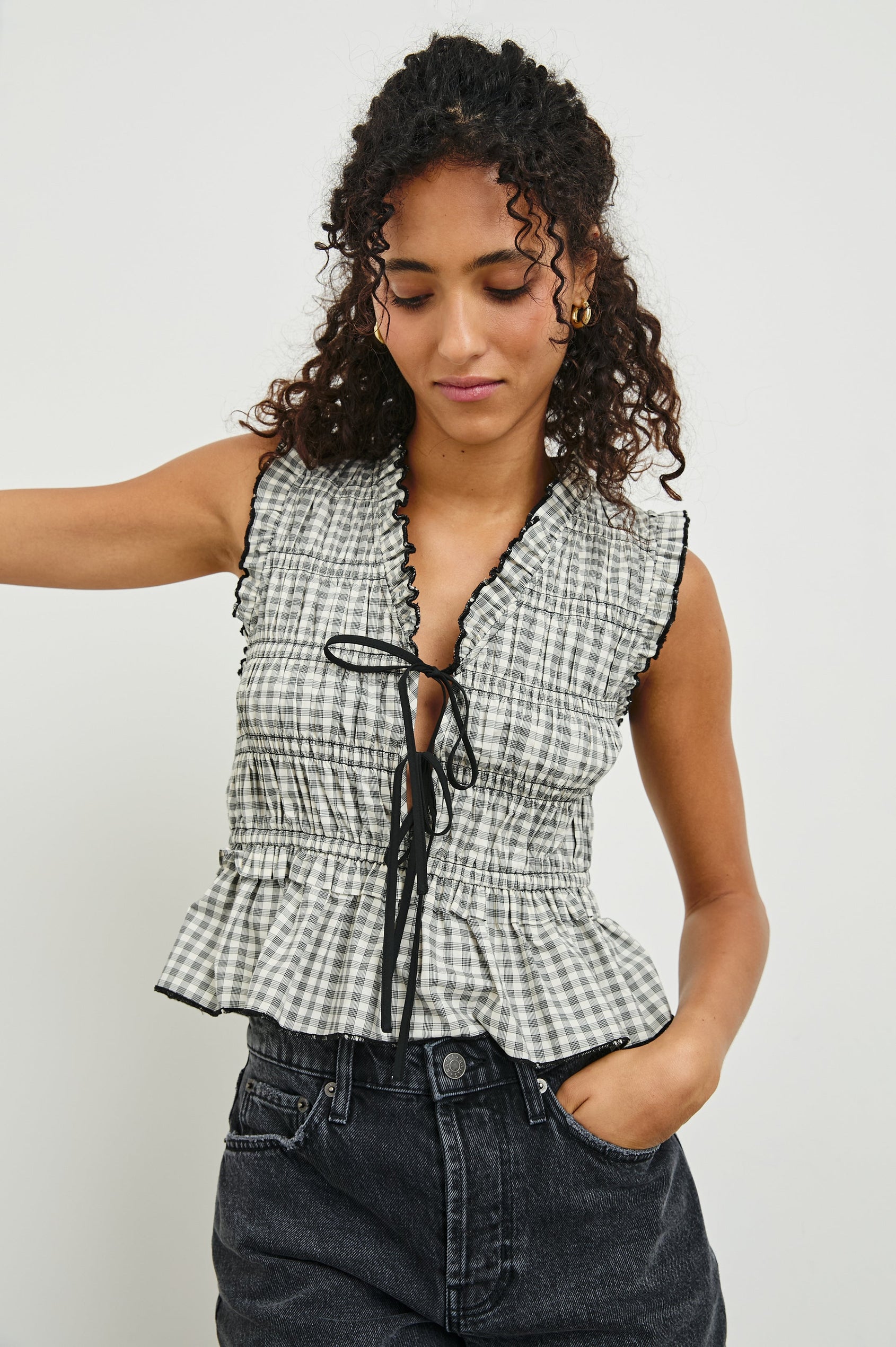 Martine Sleeveless Top with Ruffled Trim, a Deep V-Neck with Ties and Smocking in Ivory Jet Gingham Colorway - Front View Featured on Model 