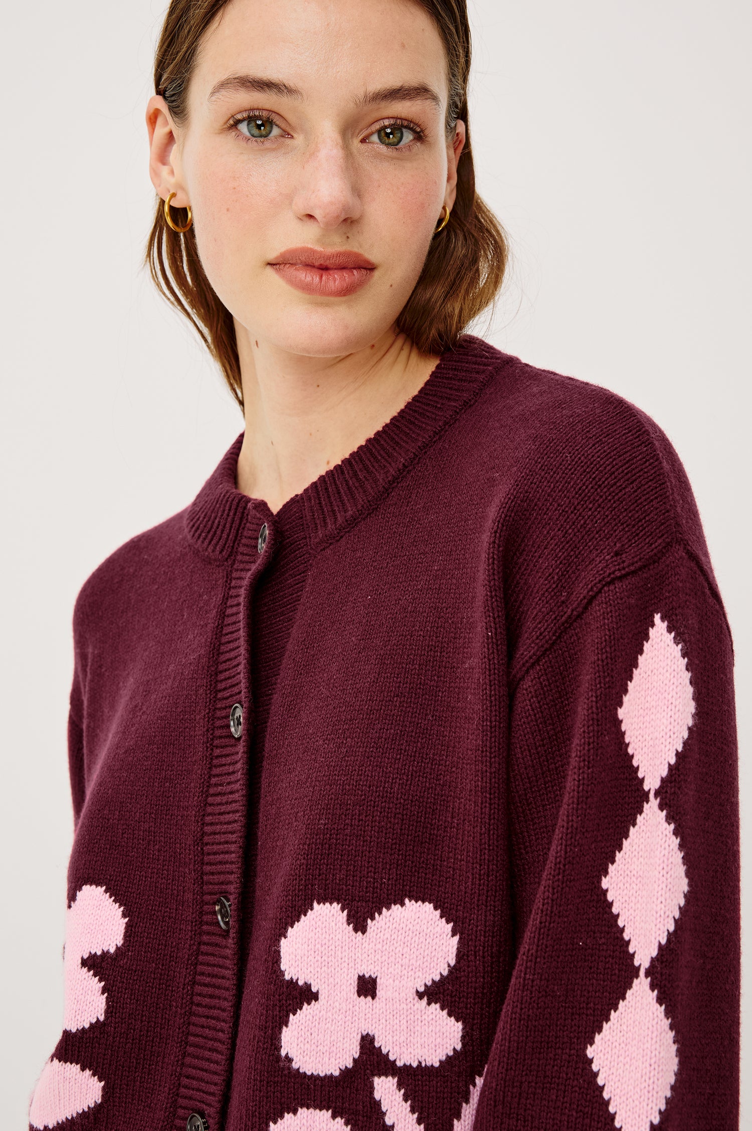 Mavie Cardigan in Wool Blend With Loose Relaxed Fit, Contrast Front Floral Motifs, Diamond Motifs at Long Sleeves, Crew Neckline, Front Buttons, and Ribbed Trim in Garnet Daisy Colorway - Upper Body Close Up Front View Featured on Model
