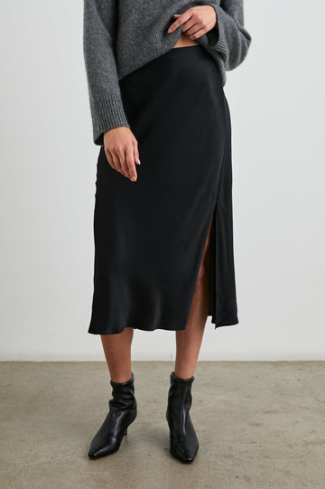 Maya Midi Skirt with Mid-Thigh Side Slit in Black Colorway - Front View Featured on Model
