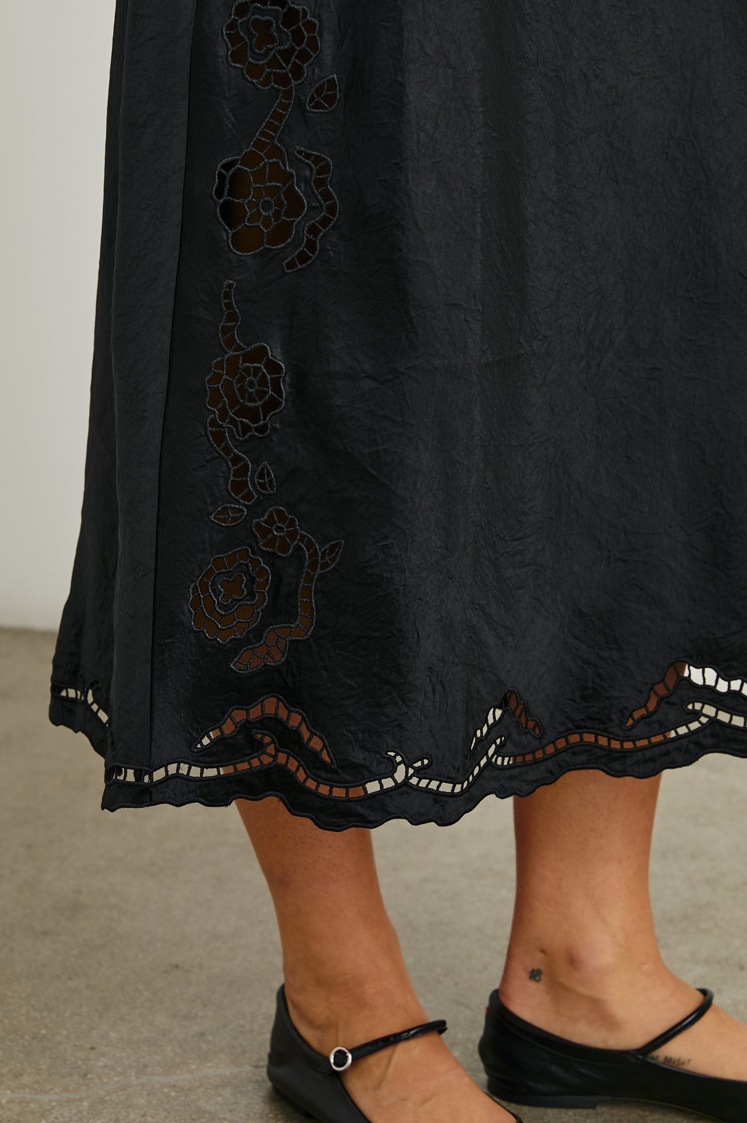 McKenna Short Sleeve Midi Dress with Flutter Sleeves, a Deep V Neck, an Eyelet Design on the Sleeves and Along the Hem and Floral Cutouts on the Skirt Sides in Black Eyelet Colorway  - Front View Featured on Model 