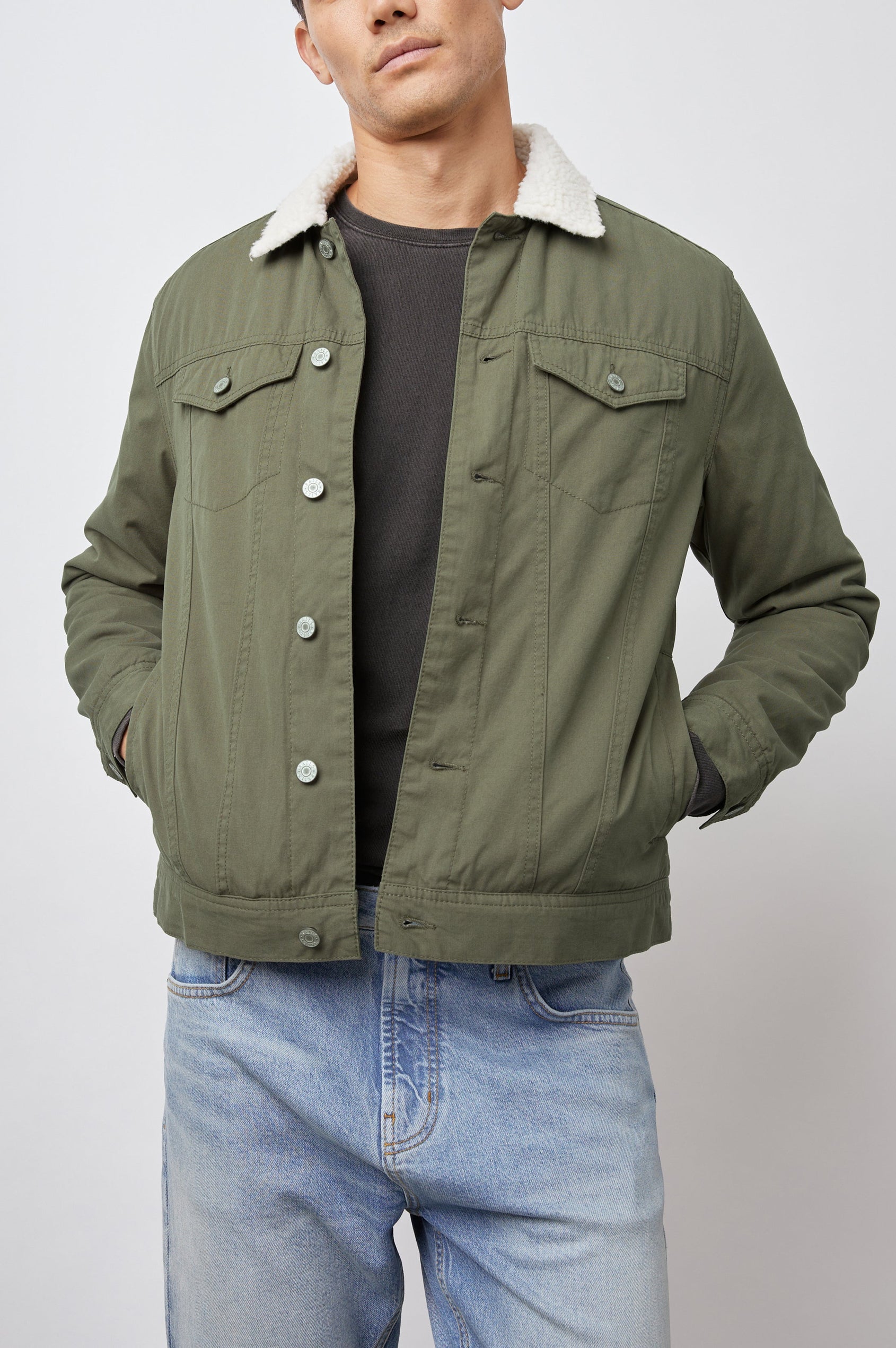 McKinley Jacket with Button Closure, Two Chest Button Flap Pockets, Two Front Pockets and a Cream Faux Sherpa Collar in Olive Colorway - Front View Featured on Model