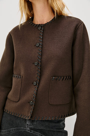 Melanie Jacket with Button Closure and Two Front Patch Pockets in Dark Brown Colorway, with Leather Whipstitching along the Trim and Pockets - Close Up View Featured on Model