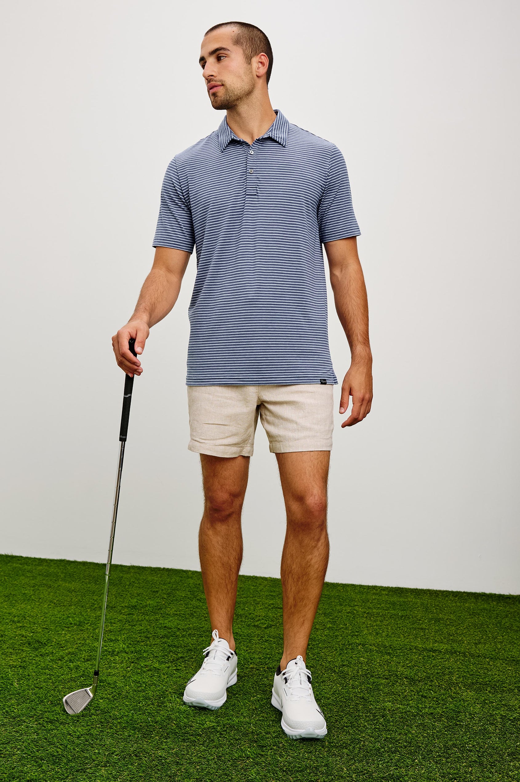 Merced Golf Polo in TENCEL™ Poly Blend With Collar, Quarter Placket, Short Sleeves, and Classic Fit in Navy Cosmo Stripe Colorway - Full Body Front View Featured on Model