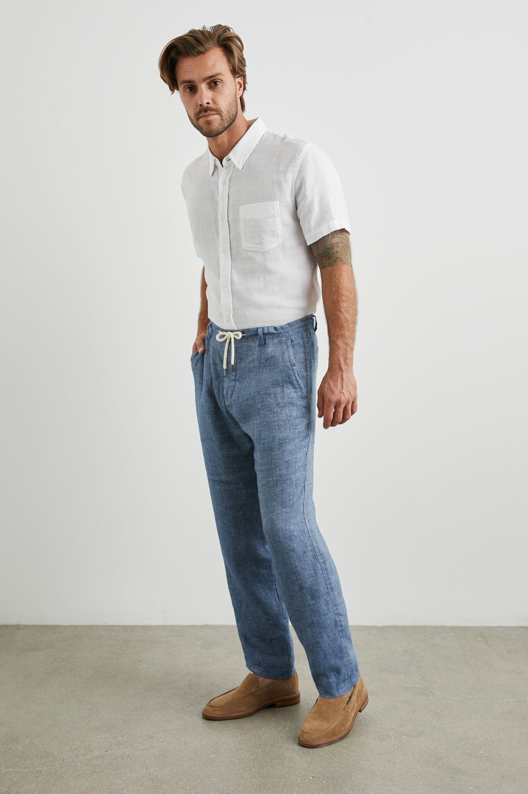 Mercer Pants with a Button and Drawcord Waist, Belt Loops, Two Front Pockets and Two Back Button Welt Pockets in Blue Mirage Colorway - Side Full Body View Featured on Model