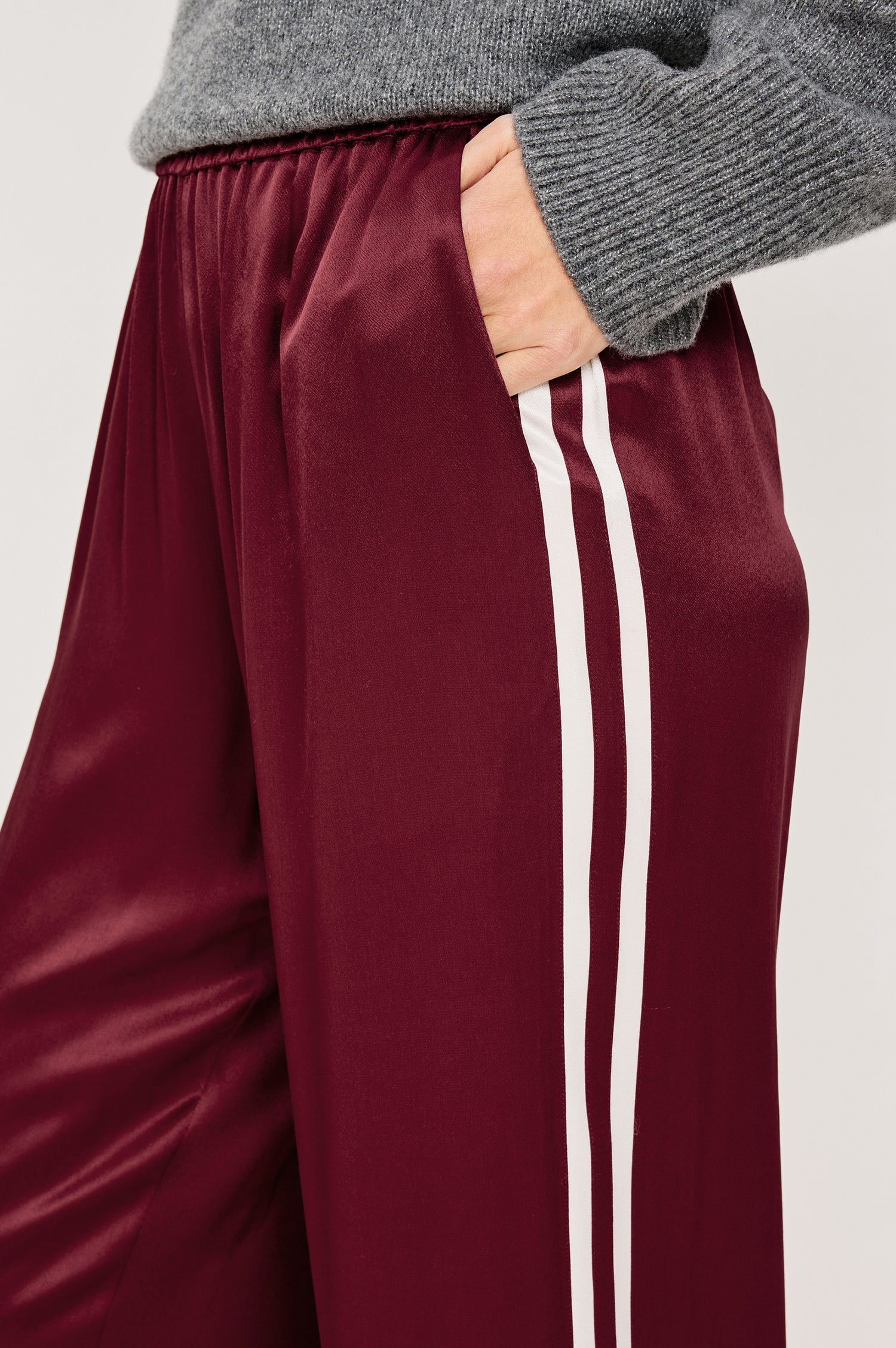 Merida Pant in Satin Back Crepe With Elastic Waistband, Side Pockets, and Wide Legs With Double Side Stripes in Garnet Colorway - Lower Body Close Up Side View Featured on Model