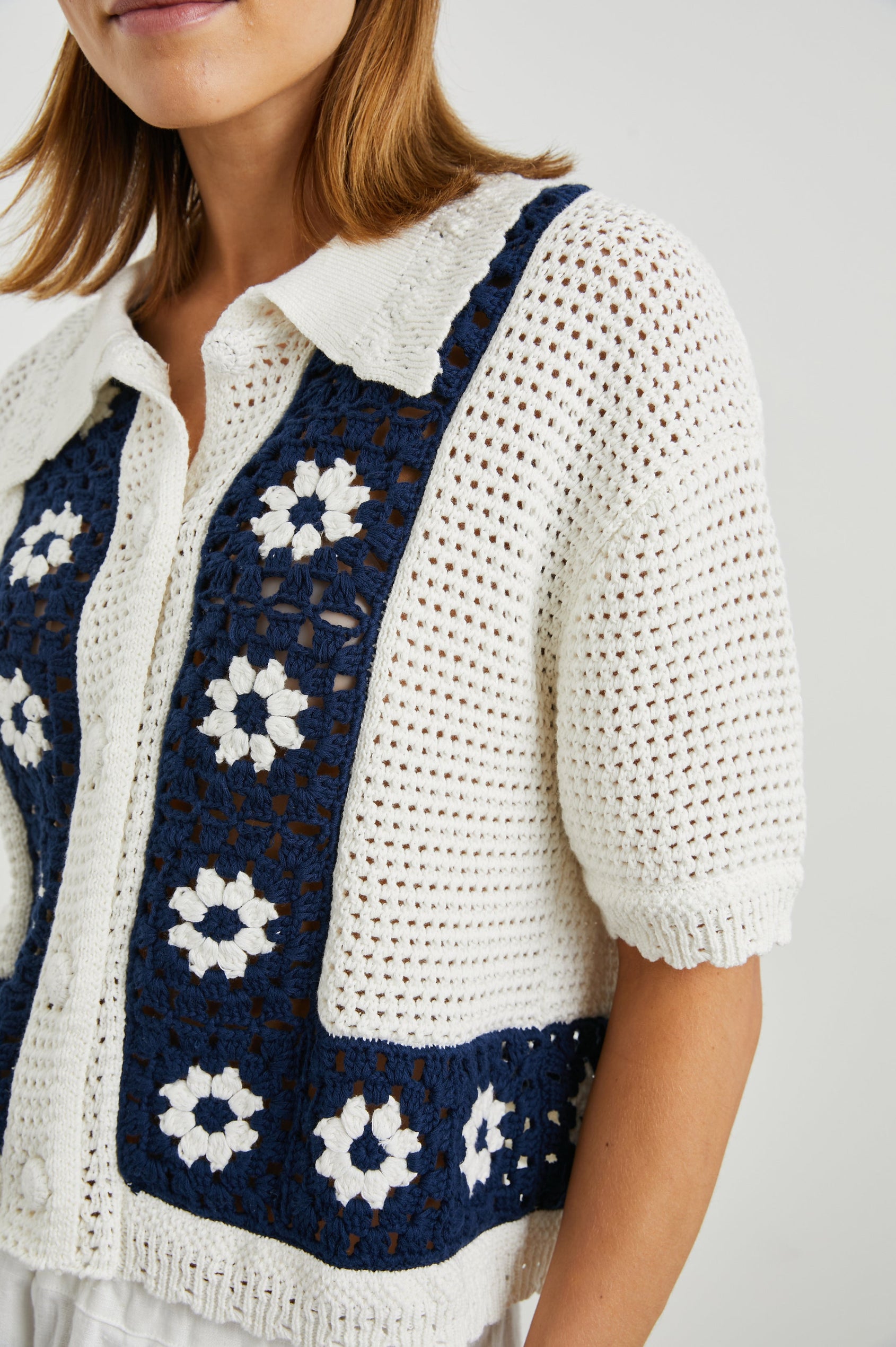 Milan Short-Sleeve Crochet Top with Front Button Closure and a Collar in Navy Crochet Daisies Colorway, White Daisies on a Navy Border on White - Front View Featured on Model 