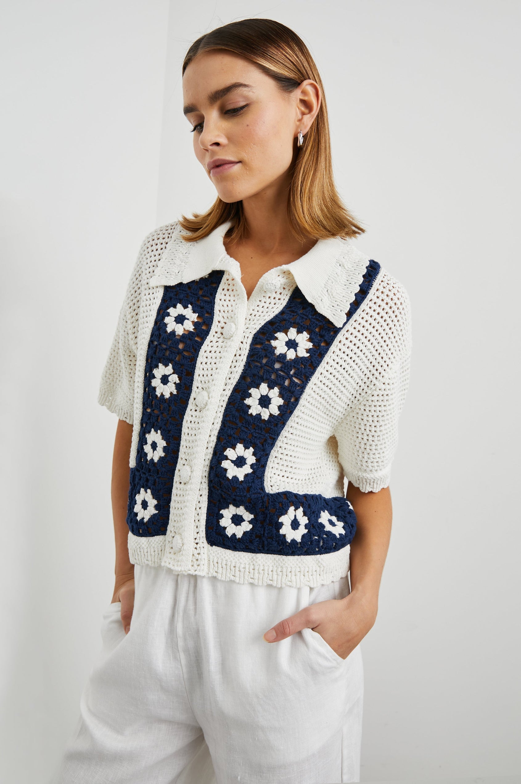 Milan Short-Sleeve Crochet Top with Front Button Closure and a Collar in Navy Crochet Daisies Colorway, White Daisies on a Navy Border on White - Front View Featured on Model 