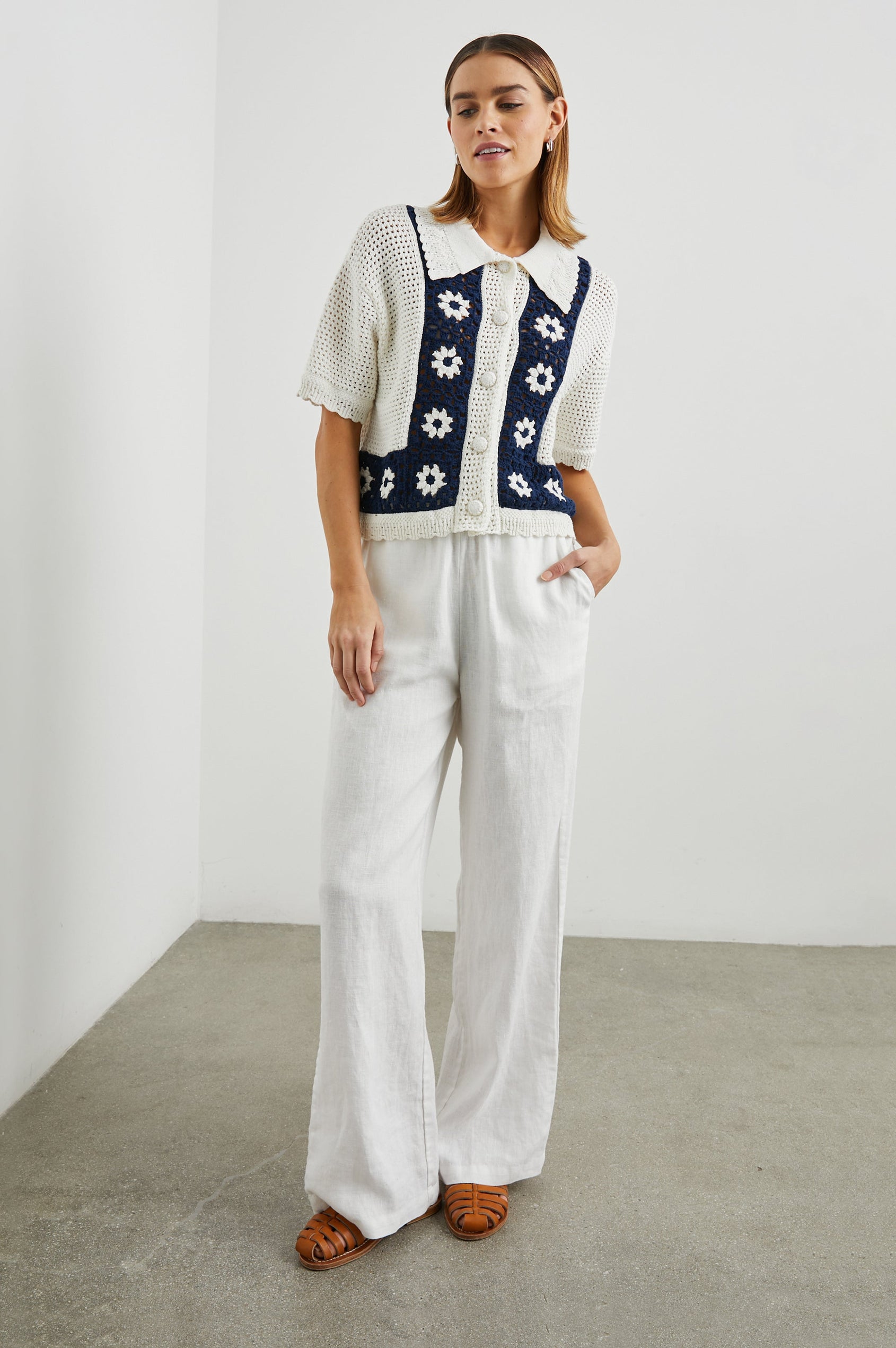 Milan Short-Sleeve Crochet Top with Front Button Closure and a Collar in Navy Crochet Daisies Colorway, White Daisies on a Navy Border on White - Front Full Body View Featured on Model 