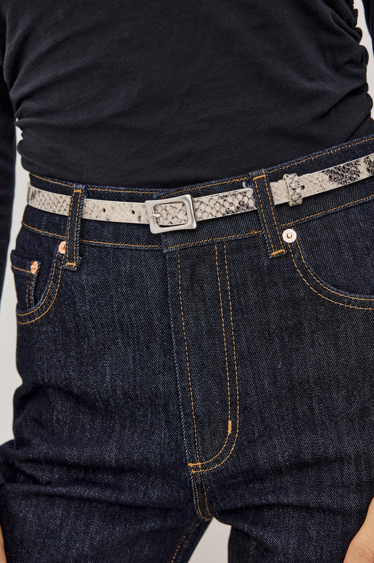 Remi Slim Leather Belt With Adjustable Buckle Closure in Ecru Python Colorway - Close Up Front Mid Body View Featured on Model