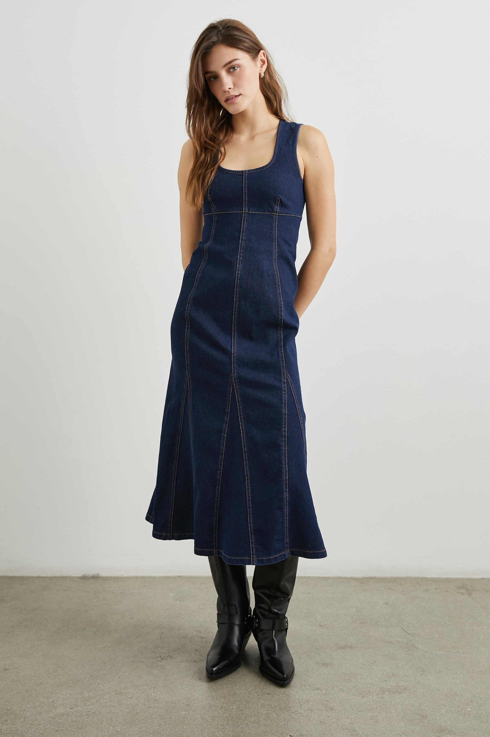 Minna Sleeveless Denim Midi Dress with Shoulder Straps, a Scoop Neck, Darting Details, and a Half Zippered Back in Rinse Indigo Colorway - Front Full Body View Featured on Model   