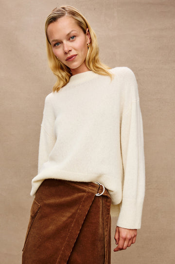 Miranda Long-Sleeve Sweater with a Mock Neck, Side Slits, and Ribbed Trim in Ivory Colorway - Stylized Front View Featured on Model