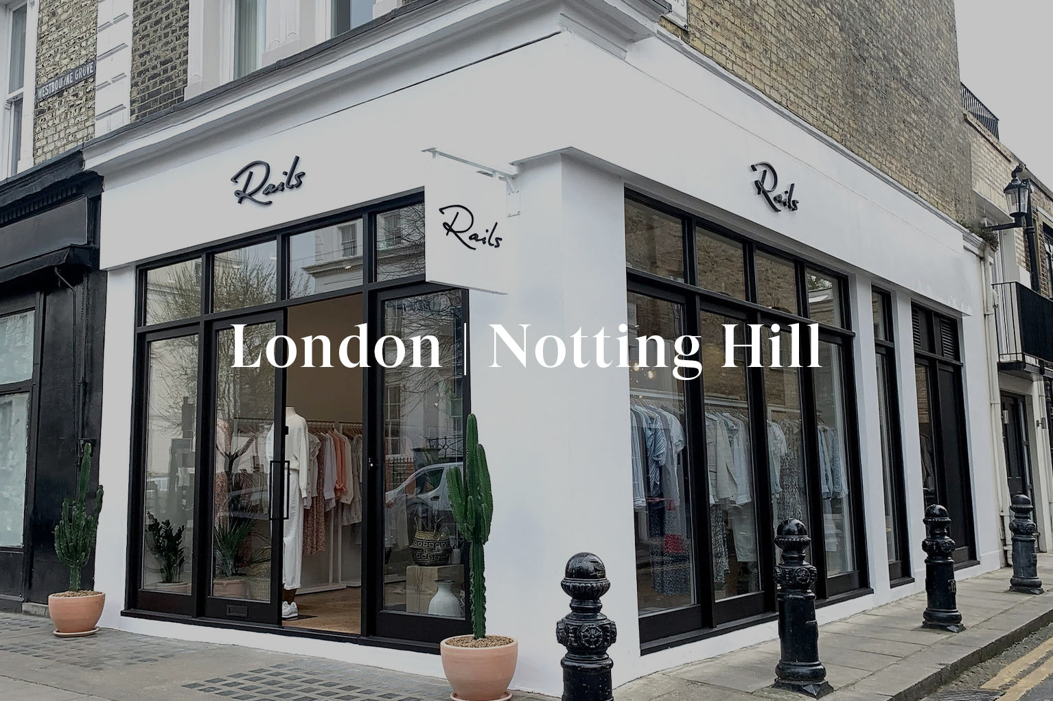 OUTSIDE OF LONDON NOTTING HILL STORE SHOWING THE FRONT ENTRANCE (TWO LARGE GLASS DOORS) AND LARGE GLASS WINDOWS ON THE SIDE OF THE BUILDING