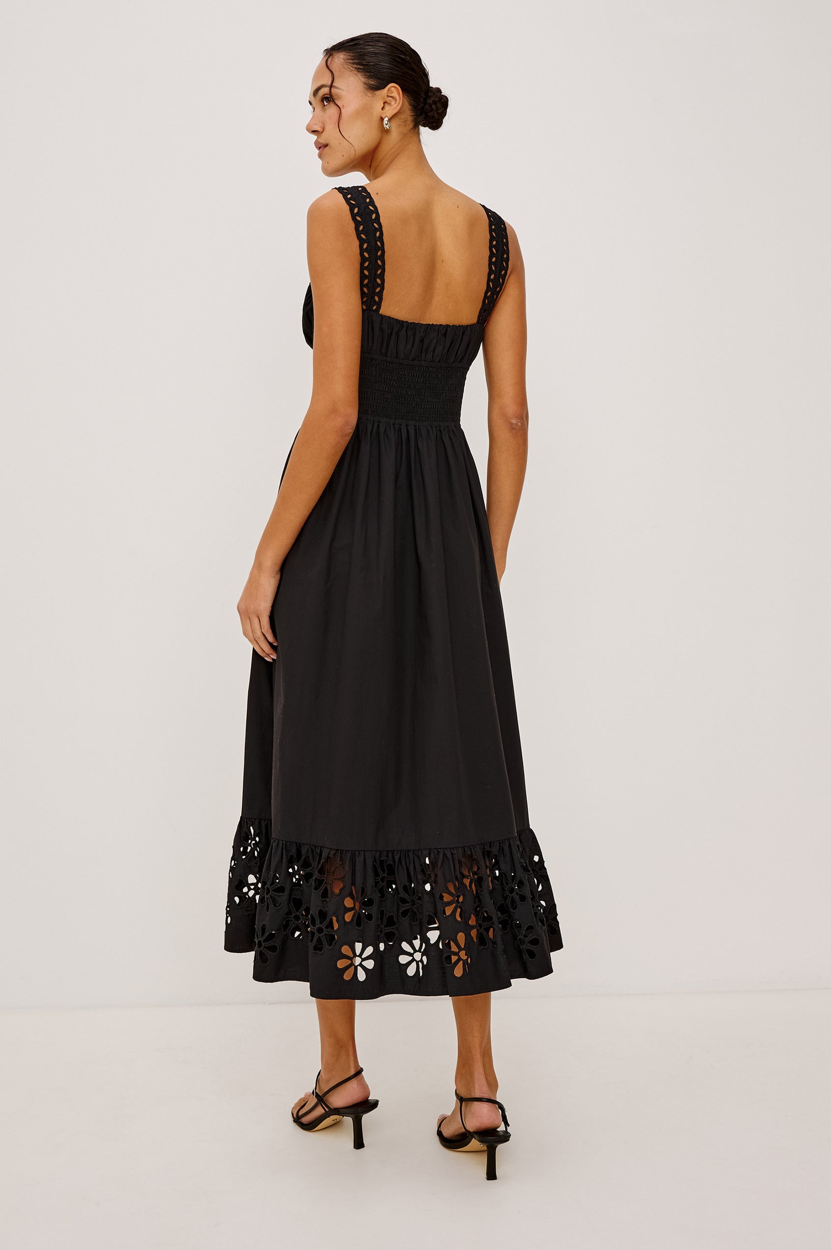 Moira Midi Dress in Cotton Poplin With Wide Embroidered Shoulder Straps, Soft Sweetheart Neckline, Smocked Empire Waist, Fully Lined Skirt With Floral Cutwork at Hem in Black Colorway - Full Body Back View Featured on Model