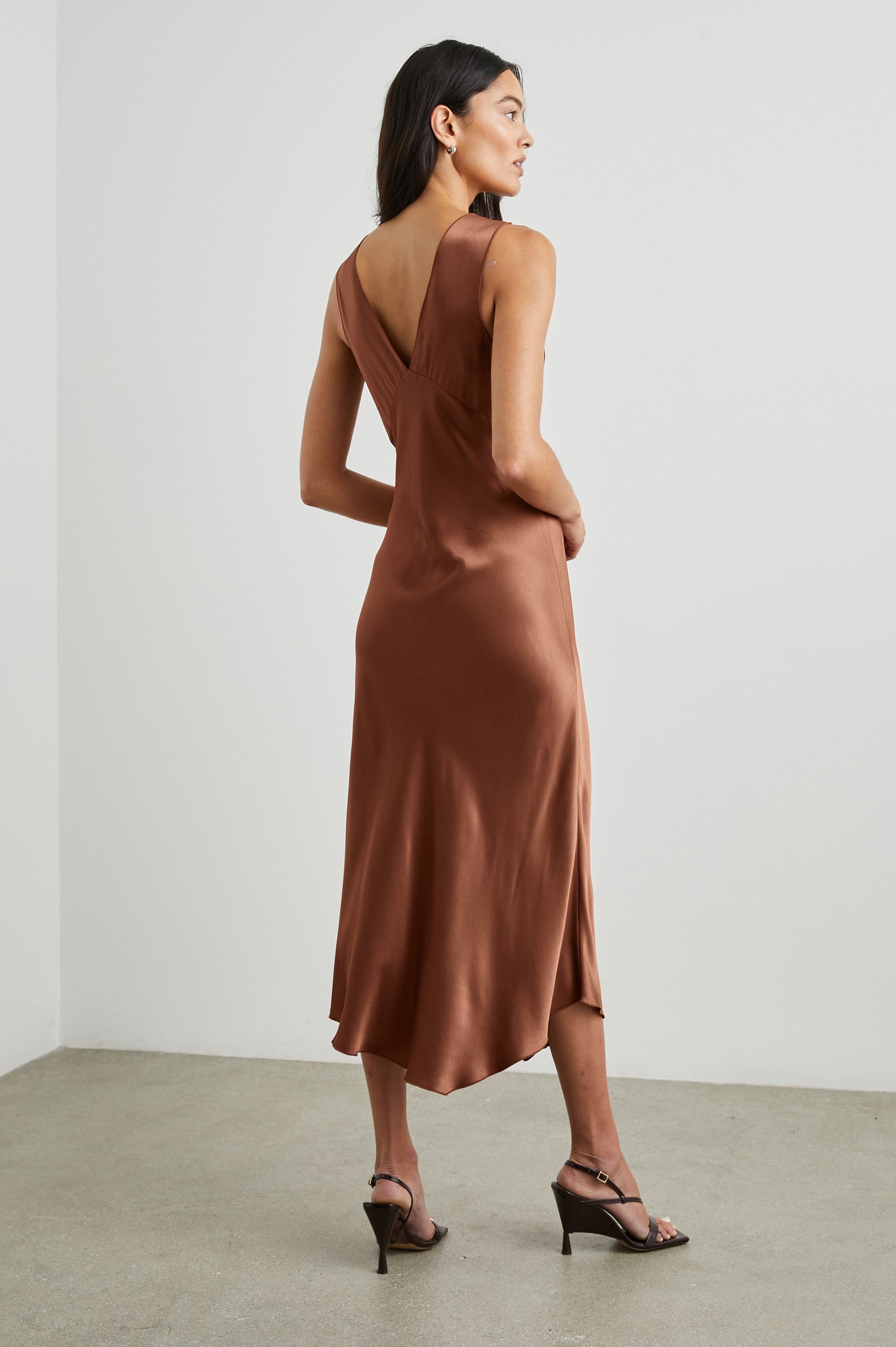Monique Sleeveless Midi Dress with an Asymmetrical Hem Line, Side Slit, Deep V Neck, and Wide Shoulder Straps in Cedar Colorway - Back Full Body View Featured on Model
